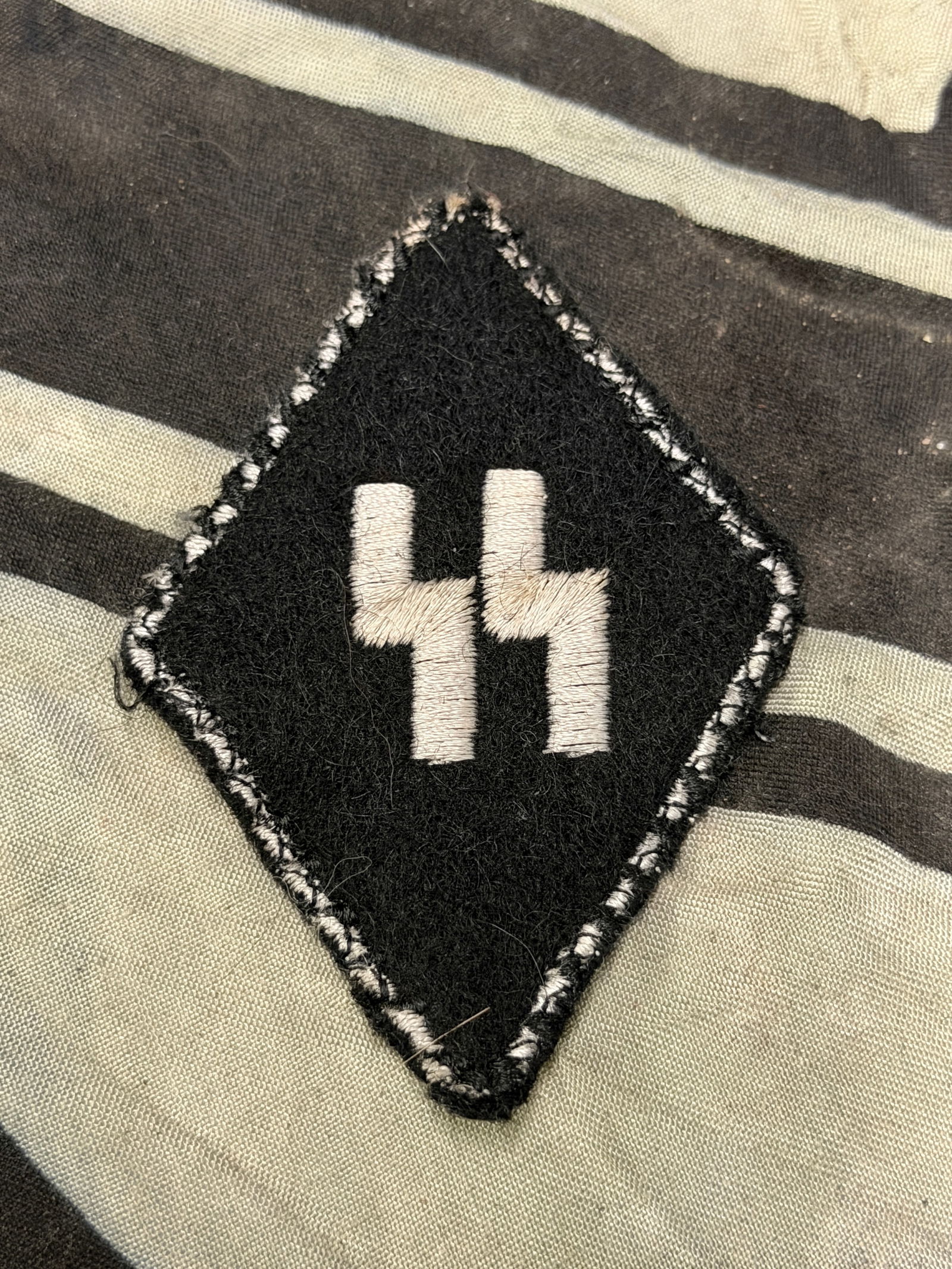 WW2 GERMAN Germanische-SS Allgemeine SLEEVE DIAMOND WITH RZM PAPER TAG: WW2 GERMAN Germanische-SS Allgemeine SLEEVE DIAMOND WITH RZM PAPER TAG. It is constructed out of a tan buckrahm base that is covered in a black wool that has hand embroidered silver bullion and black
