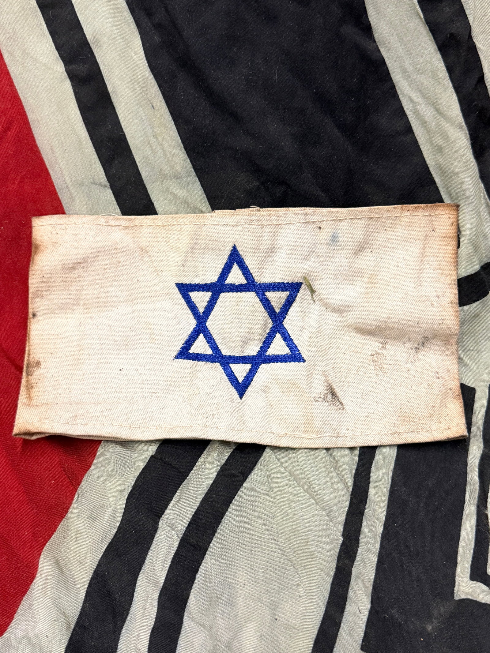 WWII GERMAN HOLOCAUST JEWISH STAR OF DAVID ARMBAND: WWII GERMAN HOLOCAUST JEWISH STAR OF DAVID ARMBAND. SHOWS GOOD WEAR AND USE WITH A BEAUTIFUL OVERALL PATINA. PLEASE VIEW ALL DETAILED PICTURES. A RARE FIND.