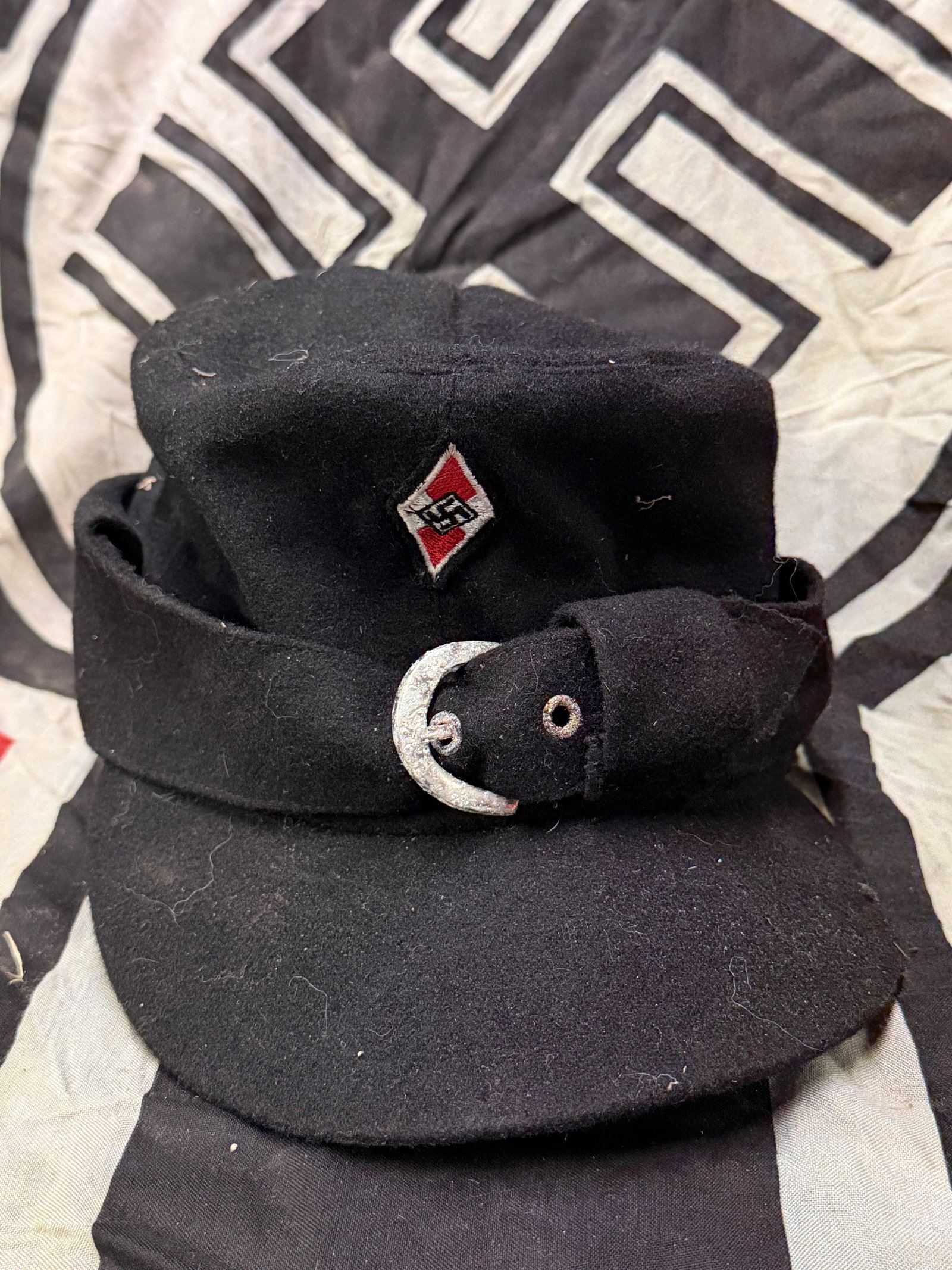A WW2 German Third Reich black cloth peaked field cap of the Hitler Youth: A WW2 German Third Reich black cloth peaked field cap of the Hitler Youth. Shos good wear and use with a beautiful overall patina. Please view all detailed pictures. A scarce example of the time perio