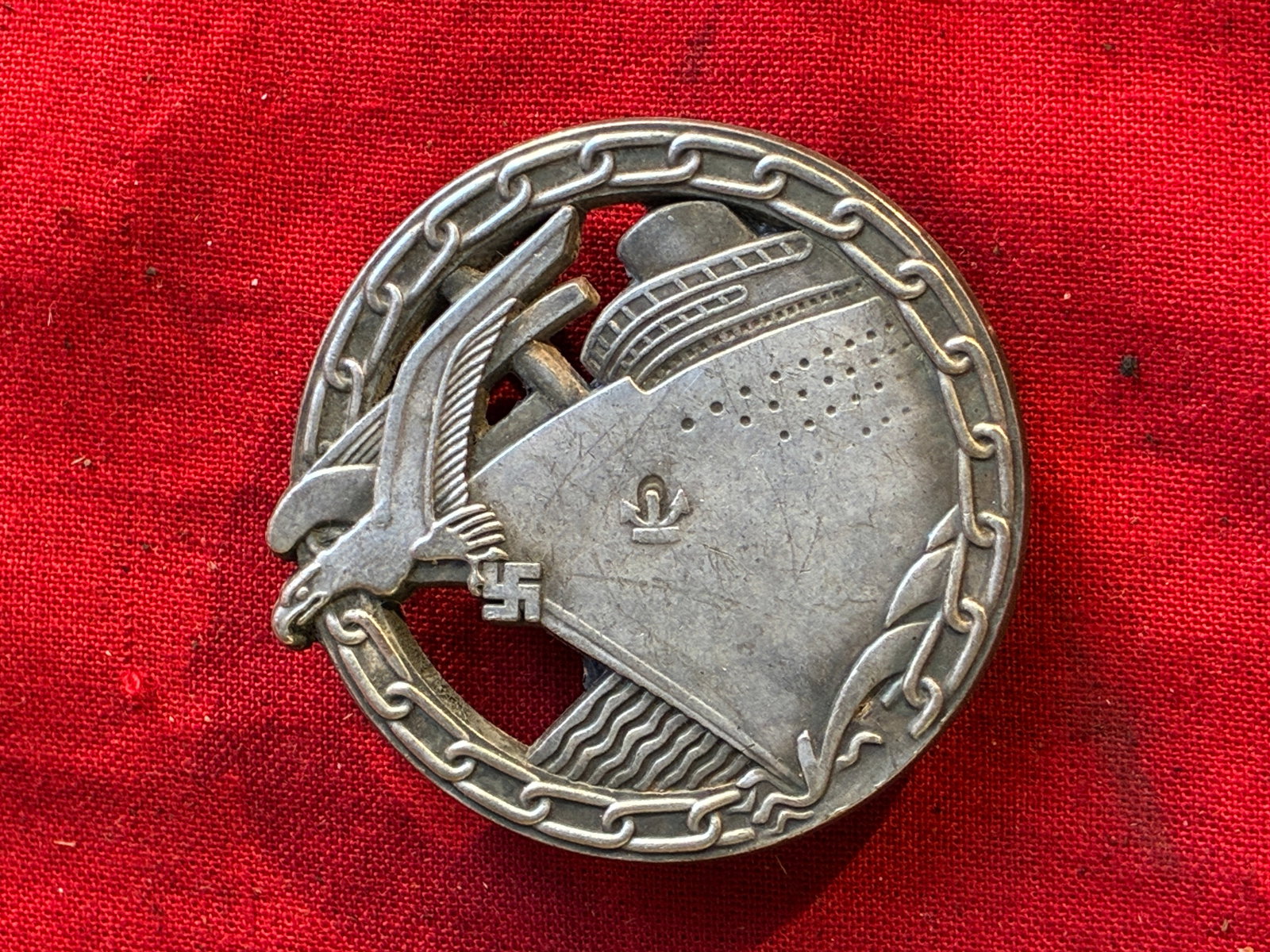 WW2 German, Kriegsmarine. A Blockade Runner Badge, By Schwerin: WW2 German, Kriegsmarine. A Blockade Runner Badge, By Schwerin. Constructed of silvered and patinated tombak, the obverse consisting of a circular chain link wreath, surrounding a central blockade run