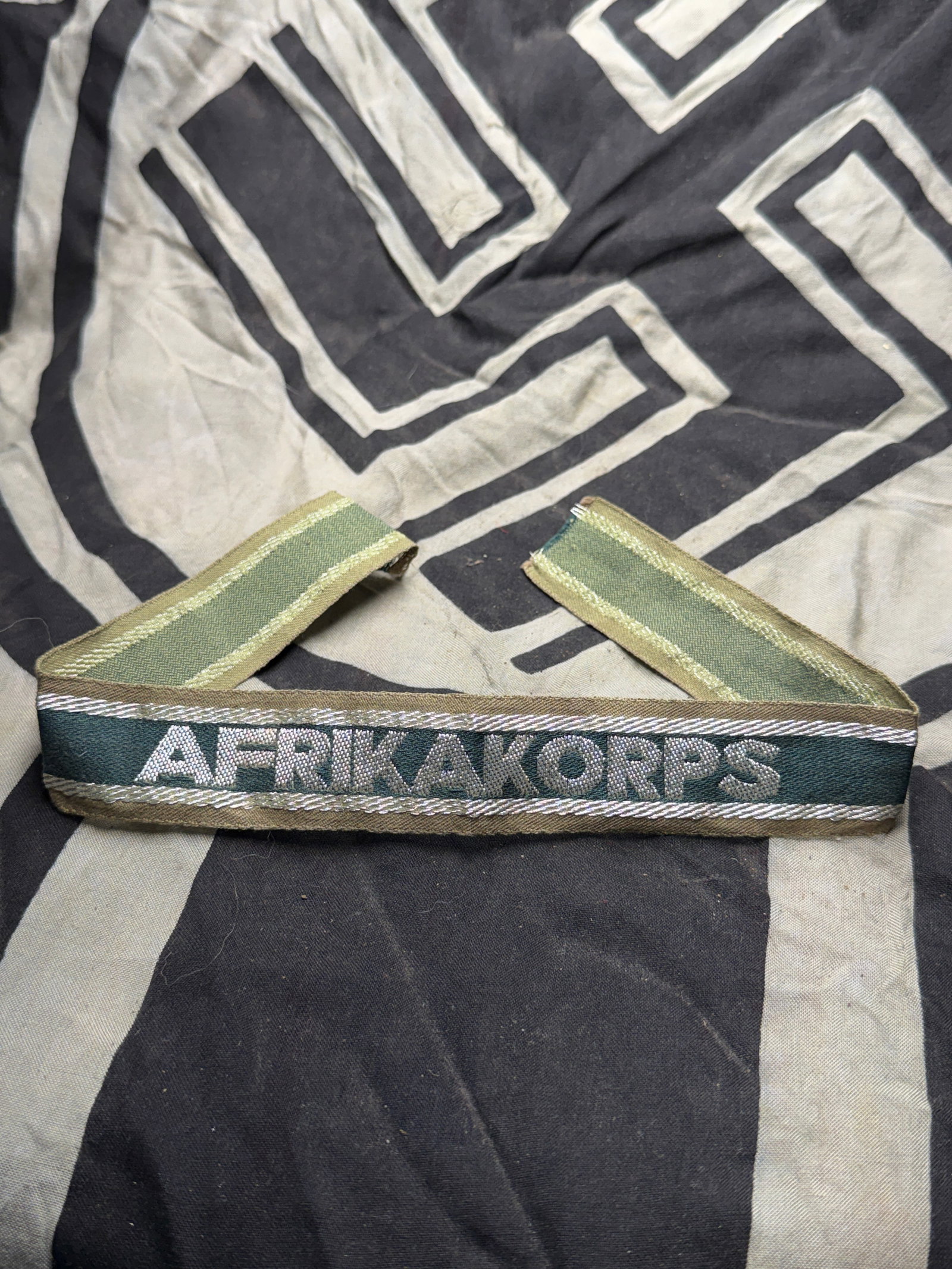 WWII GERMAN THIRD REICH AFRIKA CORPS CUFF TITLE: WWII GERMAN THIRD REICH AFRIKA CORPS CUFF TITLE. WWII German Third Reich Army Afrika Korps Officers Cuff Title, measures approx. 16.5 X 1.25 inches. The front reads "Afrika Korps." There are two flat 