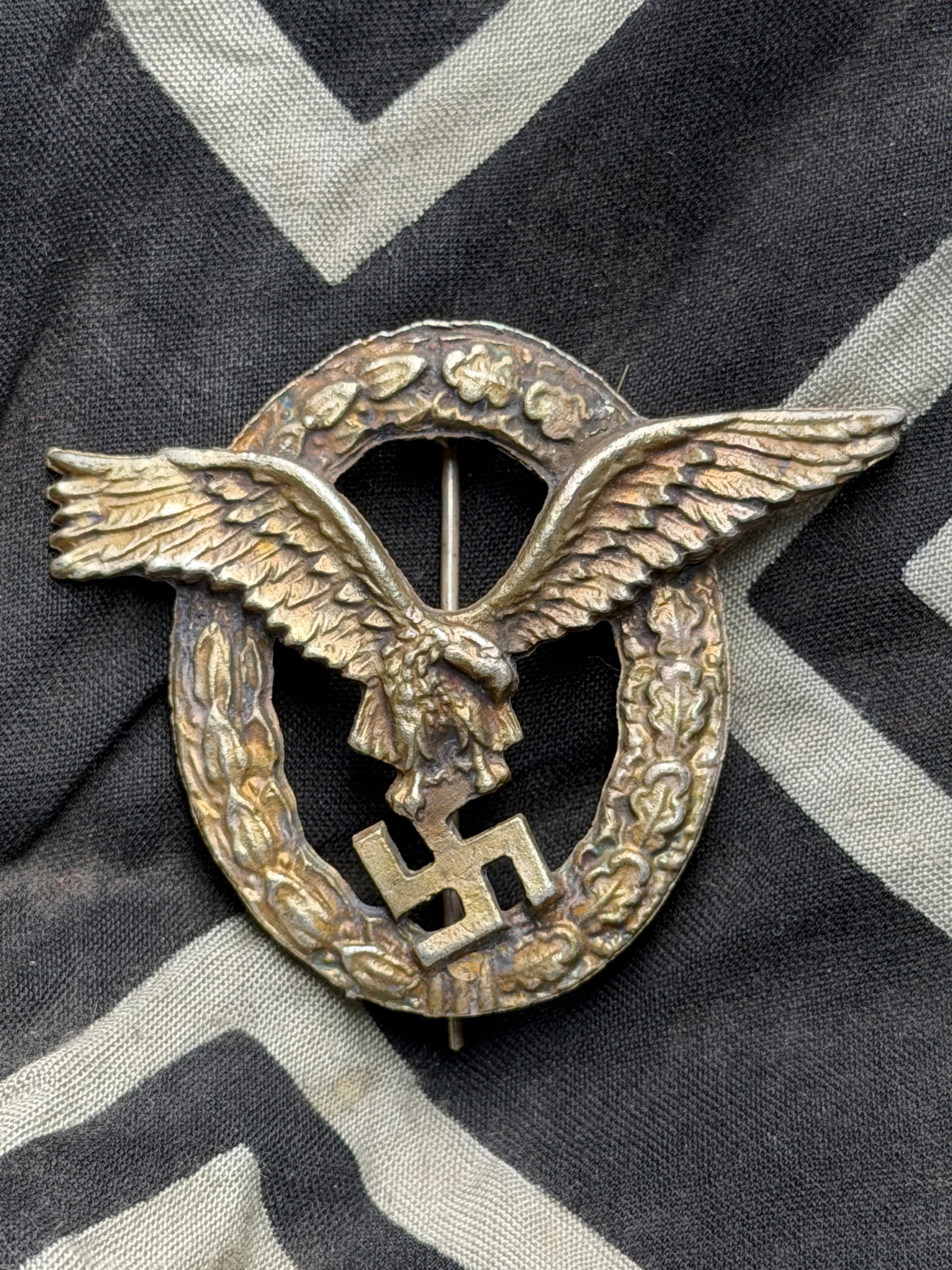 WWII German Luftwaffe Pilot Badge-Assmann Late War By RZM 800 Silver: WWII German Luftwaffe Pilot Badge-Assmann Late War By RZM 800 Silver. A rare find. Shows good wear and use with a beautiful overall patina. Please view all detailed pictures. A rare example of the tim