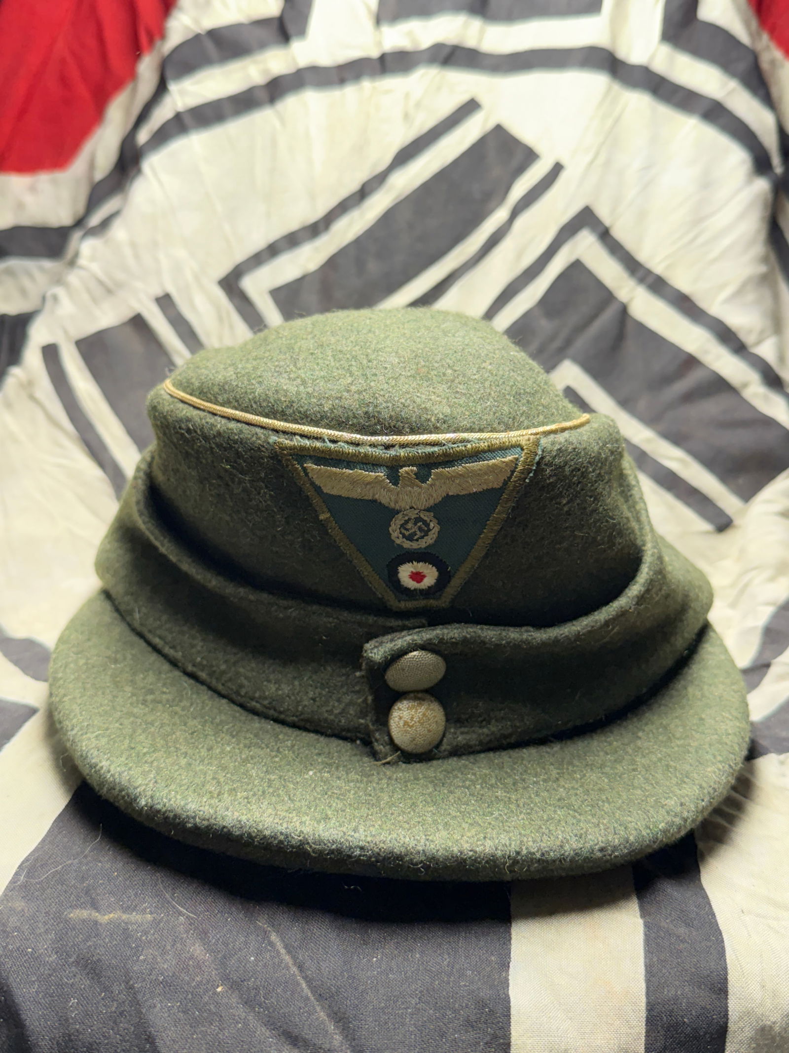 WW2 GERMAN OFFICER'S WINTER M43 FIELD CAP WITH JAGER PIN: WW2 GERMAN OFFICER'S WINTER M43 FIELD CAP WITH JAGER PIN. German officer's M43 winter field cap, bears silver braided piping denoting officer's rank encircling the top, a trapezoid BeVo insignia sewn