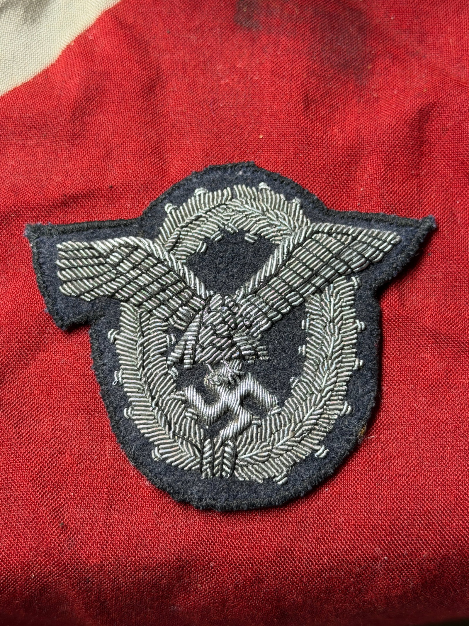 GERMAN WWII LUFTWAFFE OFFICERS PILOTS BADGE IN WIRE WEAVE: GERMAN WWII LUFTWAFFE OFFICERS PILOTS BADGE IN WIRE WEAVE. A lovely condition silver Luftwaffe pilot style eagle on its silver wreath on enlisted mans quality backing cloth. Unissued condition.