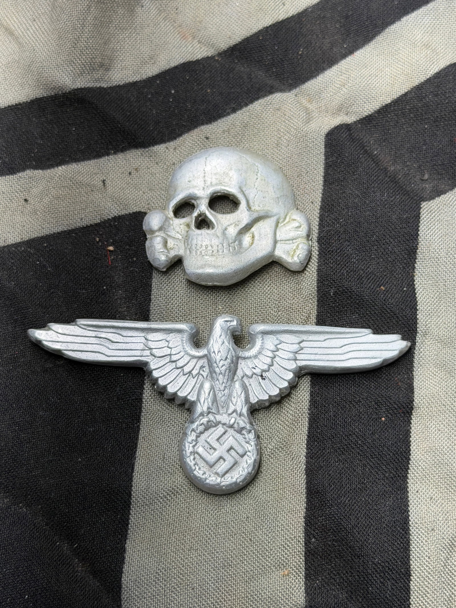 SET OF (2) WW2 GERMAN TOTENKOPF SS OFFICER VISOR CAP EAGLE AND DEATH SKULL BY RZM: SET OF (2) WW2 GERMAN TOTENKOPF SS OFFICER VISOR CAP EAGLE AND DEATH SKULL BY RZM. THIS IS A COMPLETE SET. BOTH THE INSIGNIA'S ARE MAKER MARKED. SHOWS GOOD WEAR AND USE WITH A BEAUTIFUL OVERALL PATINA