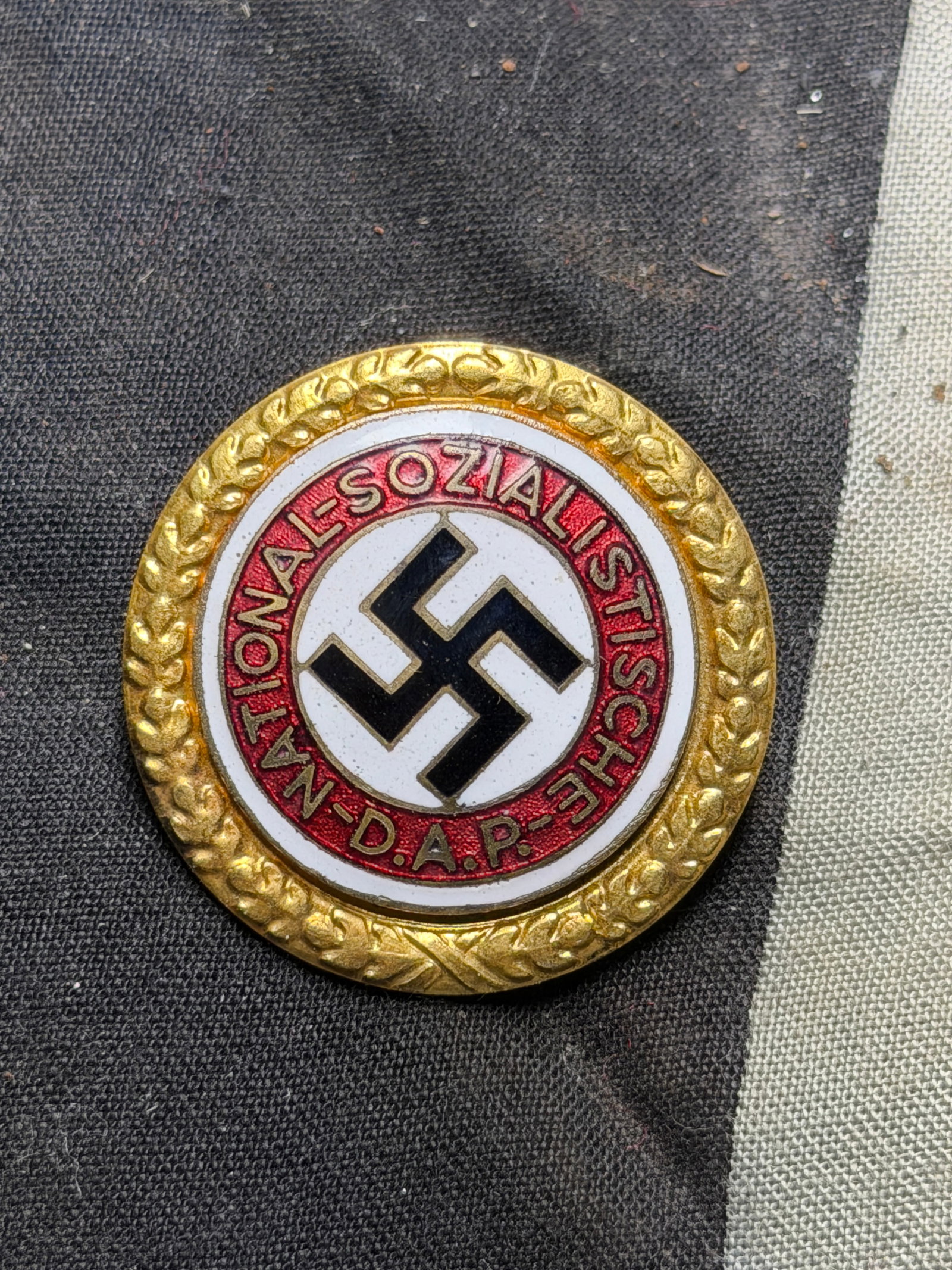 Large WW2 German NSDAP Golden Party Badge “1025: Large WW2 German NSDAP Golden Party Badge “1025”. The large Gold Party Badge, meant for wear on a military uniform, is in very good condition. The gilt wreath exhibits age toning and wear to t