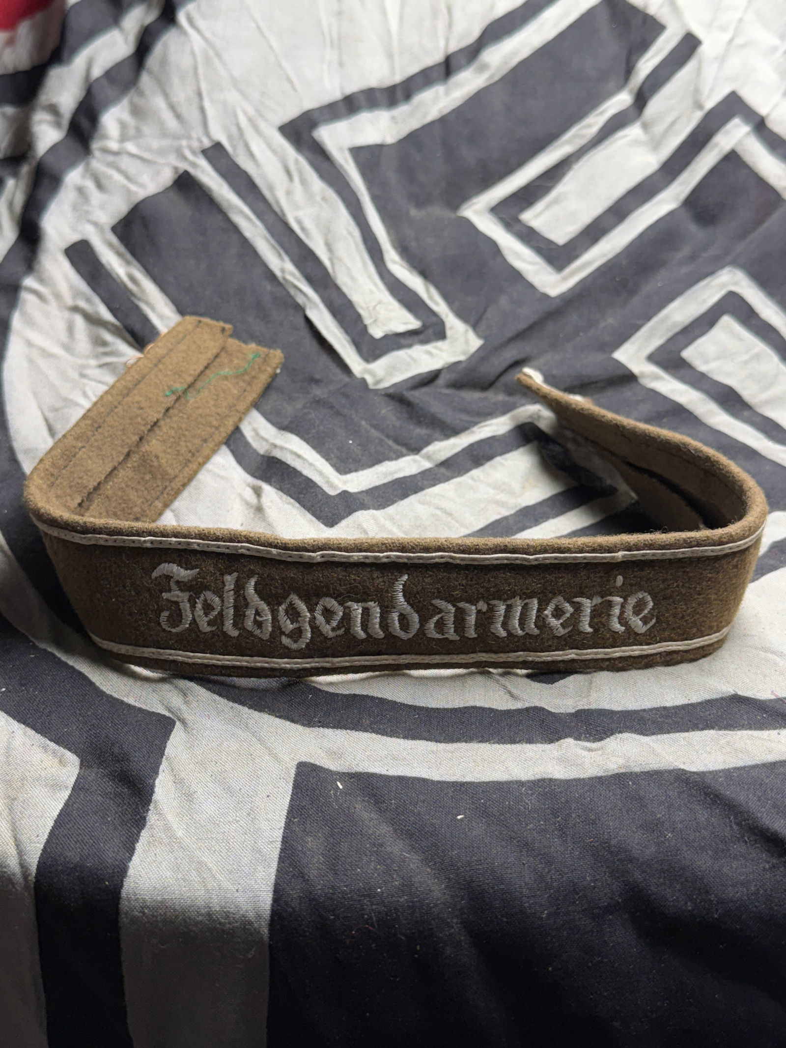 WW2 Germany, Heer. A Feldgendarmerie Cuff Title: WW2 Germany, Heer. A Feldgendarmerie Cuff Title. (Feldgendarmerie Ärmelband). Constructed of olive-drab wool, the exterior trimmed along both the top and bottom edges with silver aluminum wire piping
