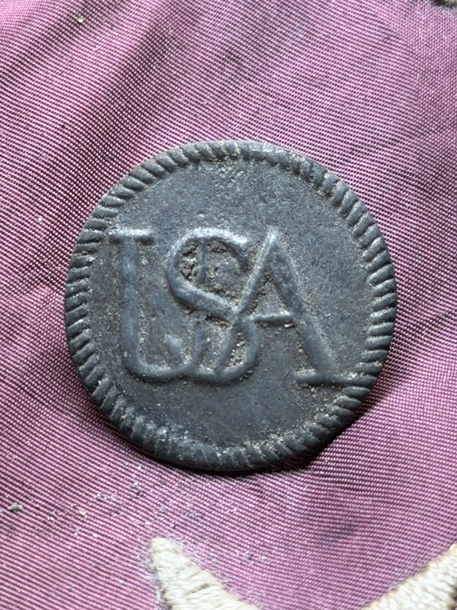 Revolutionary War USA Pewter Uniform Button, Circa 1777–1783: This pewter uniform button features the raised, interlocking letters “USA”, surrounded by a rope-style border. The back of the button retains a cast shank loop, typical of 18th-century America