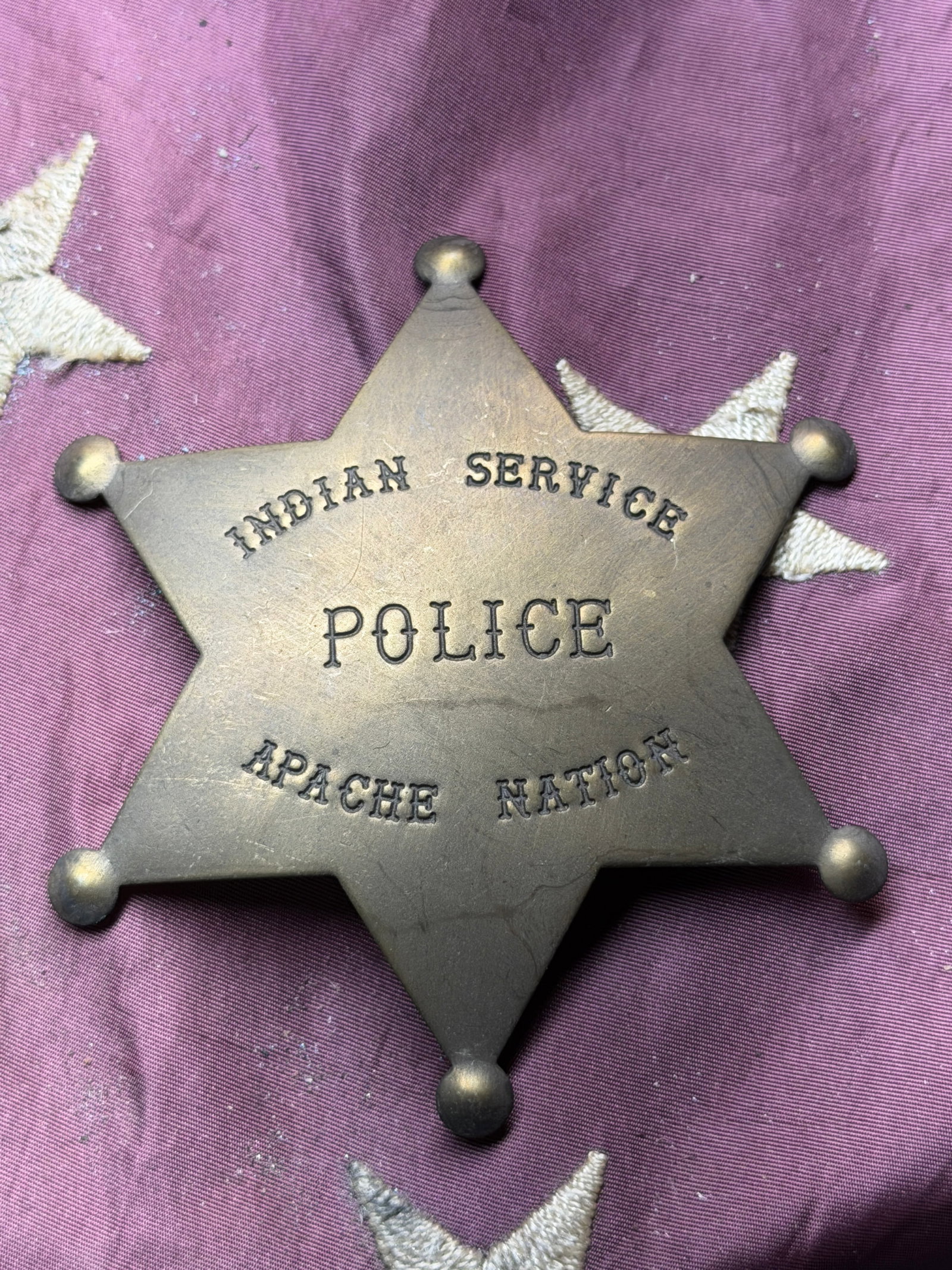 Apache Nation Indian Service Police Badge – Early 20th Century: This six-pointed star badge, stamped “Indian Service Police – Apache Nation,” is made of brass and measures approximately 3.5 inches (8.9 cm) in diameter. The badge follows the classic Weste