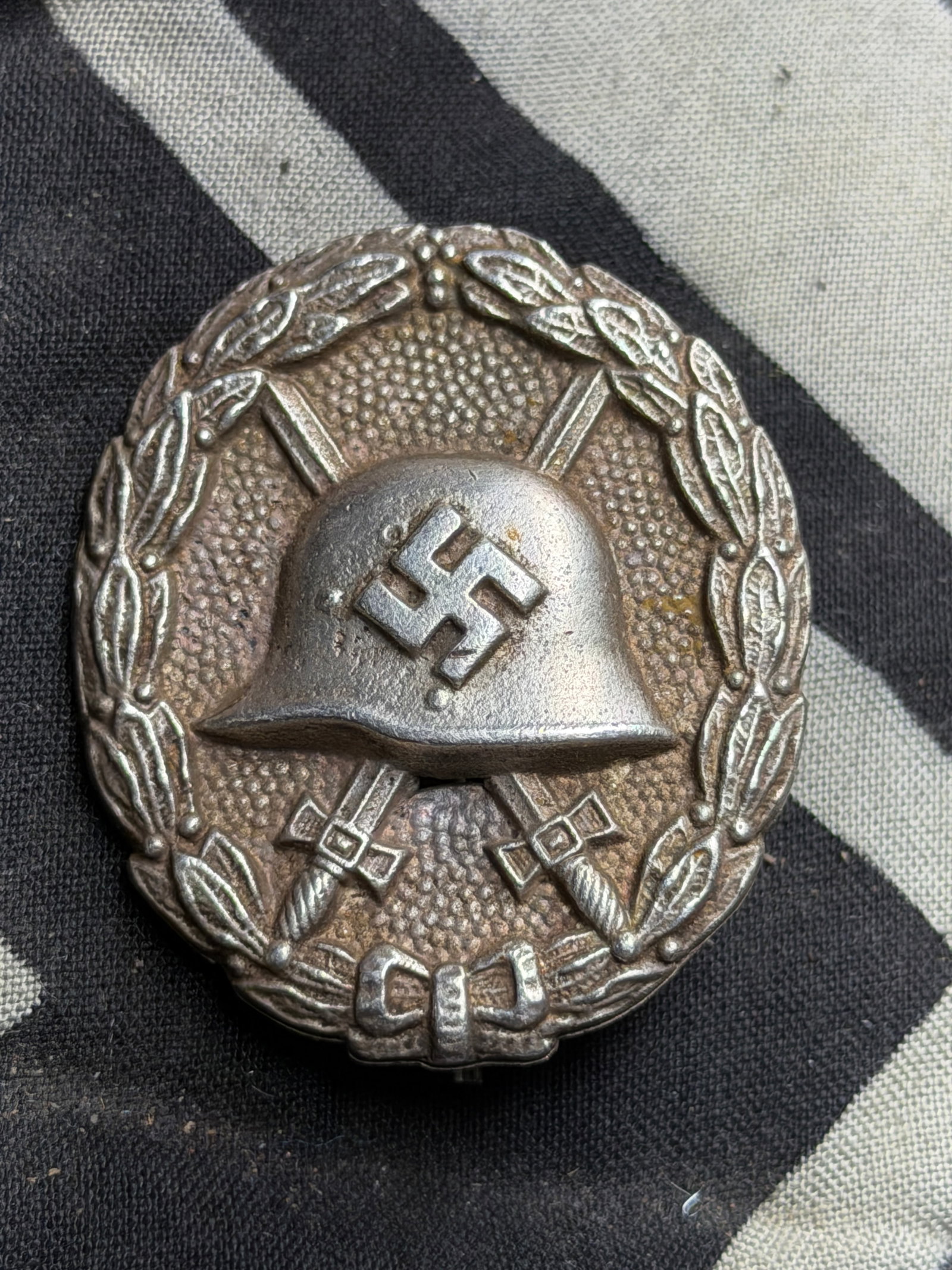 WW2 Germany, Wehrmacht. A Silver Grade Wound Badge, First Pattern: WW2 Germany, Wehrmacht. A Silver Grade Wound Badge, First Pattern. (Verwundetenabzeichen in Silber). Constructed of silvered bronze, the obverse consisting of an oval laurel leaf wreath with scalloped
