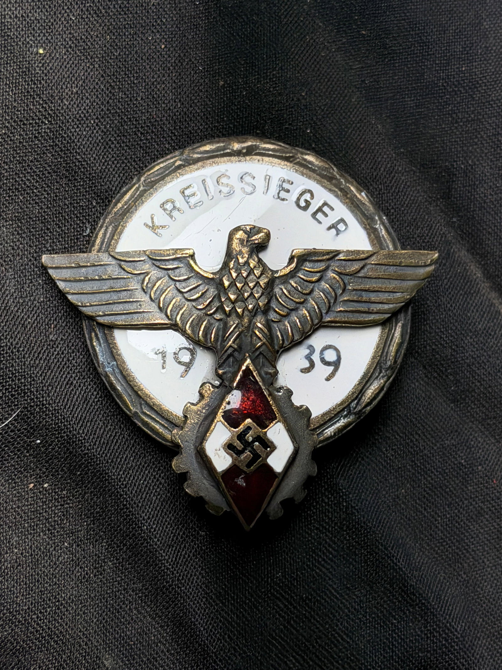 WW2 Hiter Youth Kreis Sieger Award Badge — Germany, 1939 By G. Brehmer, Markneukirchen: WW2 Hiter Youth Kreis Sieger Award Badge — Germany, 1939 By G. Brehmer, Markneukirchen. This enameled metal badge, marked “KREISSIEGER 1939” (“District Champion 1939”), was awarded a