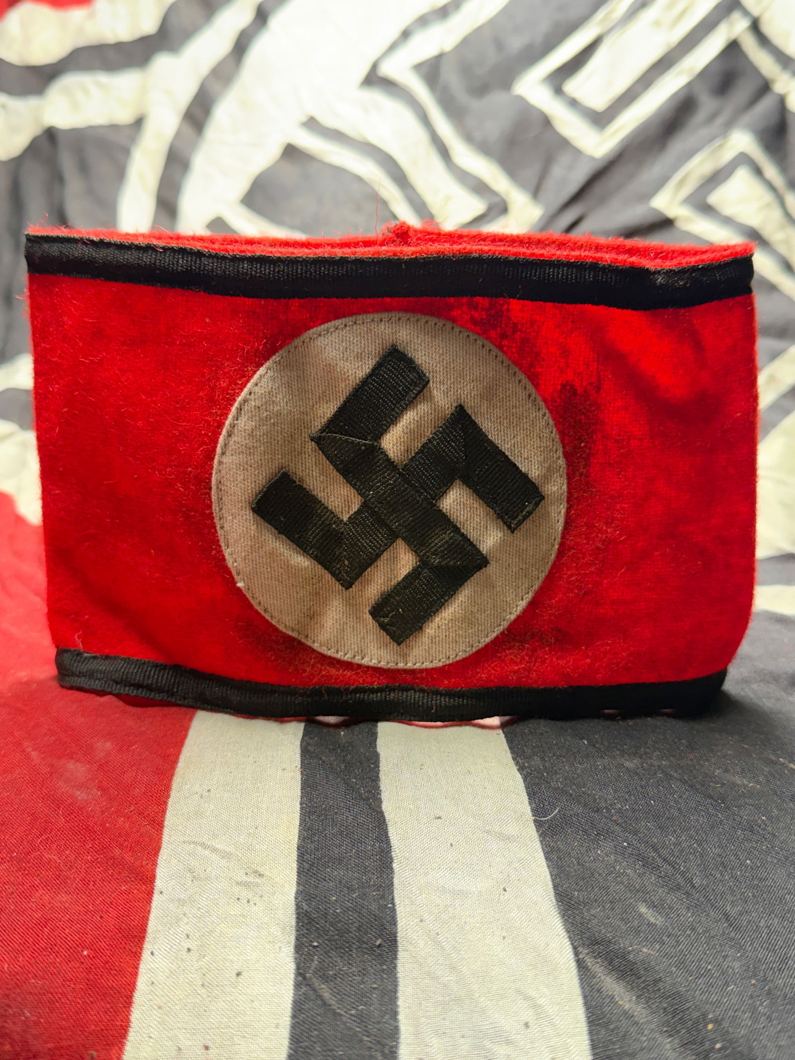 WW2 German SS Armband Schutzstaffel (SS) Enlisted Personnel With RZM Cloth Sewn Tag: WW2 German SS Armband Schutzstaffel (SS) Enlisted Personnel With RZM Cloth Sewn Tag. This red wool armband features a white circular field bearing a black swastika, bordered with black cotton trim alo