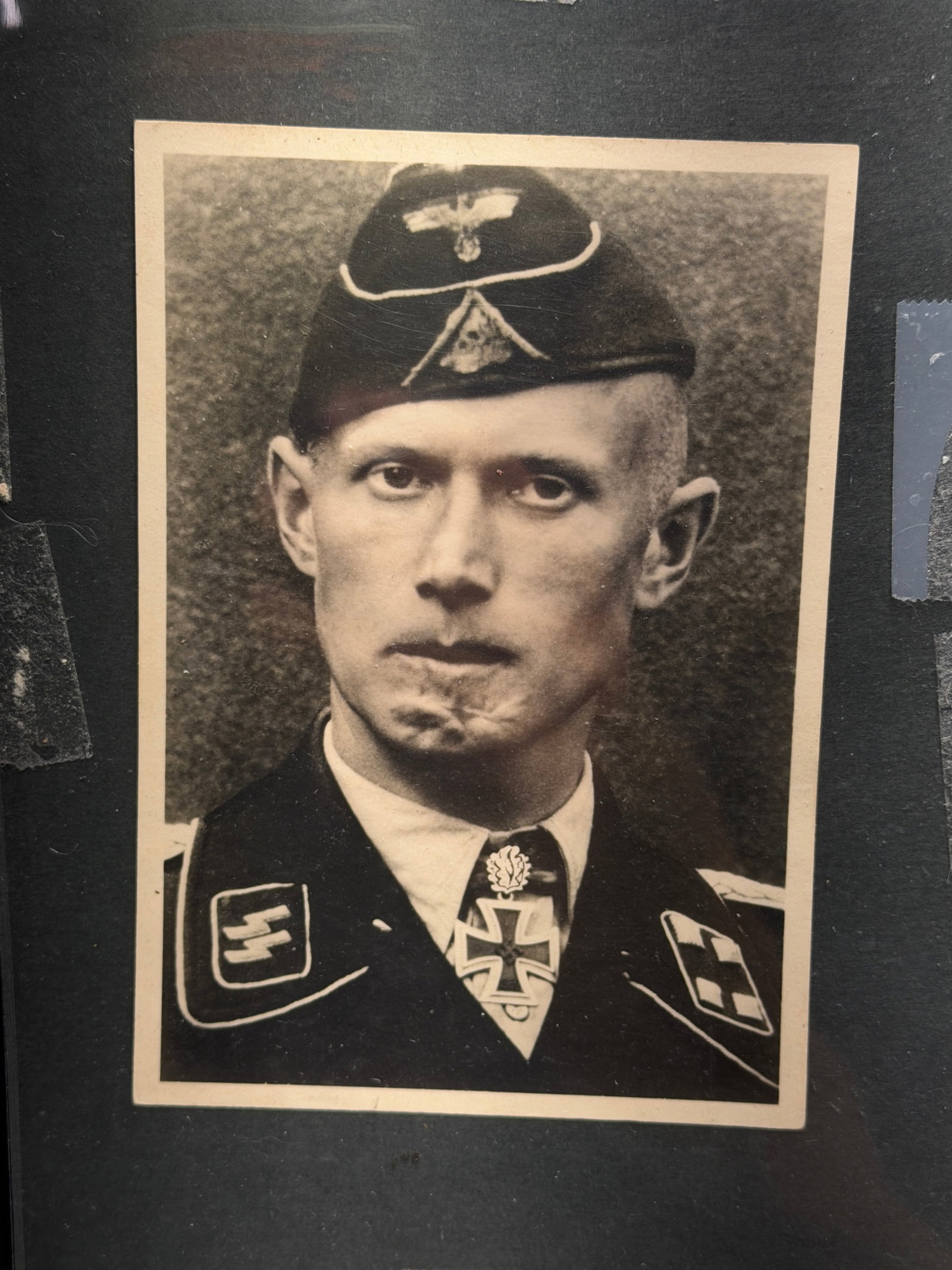WW2 German Portrait Postcard of Injured SS Officer (circa 1940s): WW2 German Portrait Postcard of Injured SS Officer (circa 1940s). This black-and-white photographic postcard depicts a uniformed officer of the Schutzstaffel (SS), an elite paramilitary organization o