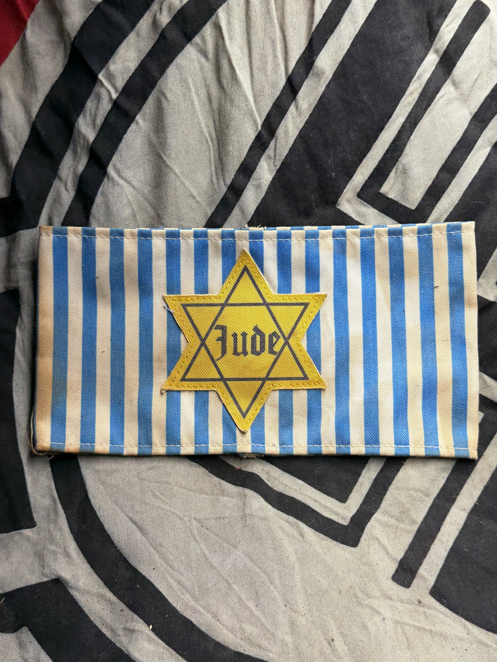RARE WW2 GERMAN JEWISH JUDE CONCENTRATION CAMP ARMBAND WITH STAR OF DAVID: RARE WW2 GERMAN JEWISH JUDE CONCENTRATION CAMP ARMBAND WITH STAR OF DAVID. This armband, displaying the yellow Star of David with the word “Jude” (German for “Jew”) printed in black Go