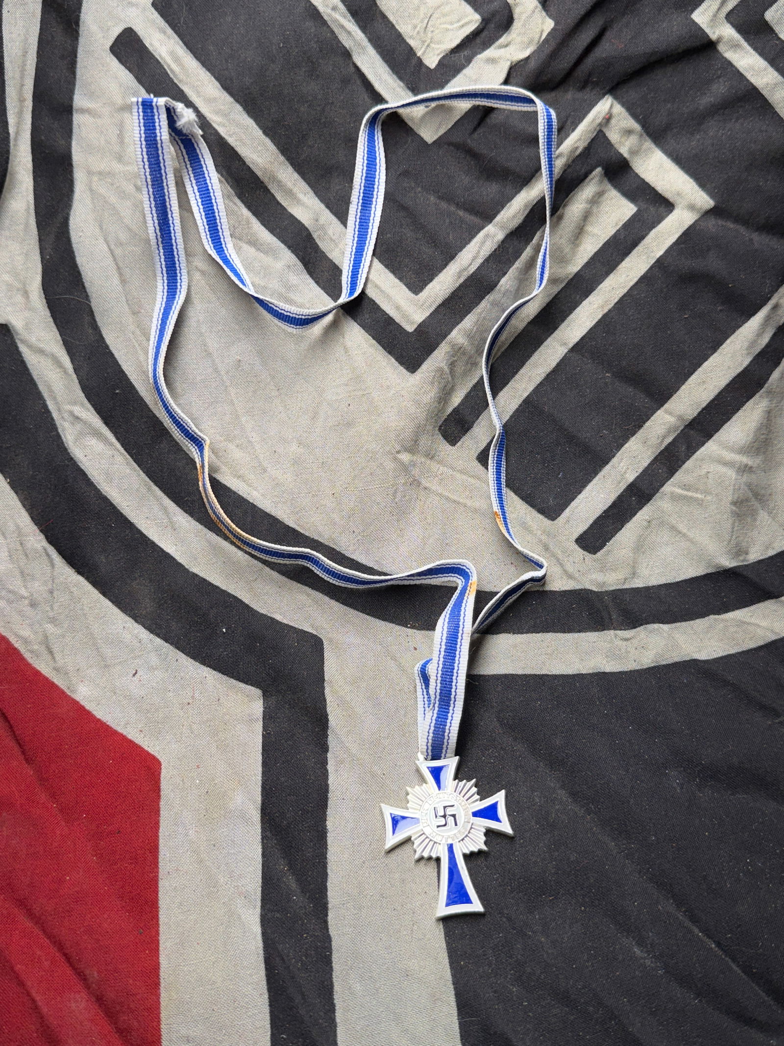 WW2 German Cross of Honour of the German Mother (Ehrenkreuz der Deutschen Mutter) — Bronze Class,: WW2 German Cross of Honour of the German Mother (Ehrenkreuz der Deutschen Mutter) — Bronze Class, 1938. This enameled medal, approximately 4.5 cm in height, features a blue and white Maltese-style c