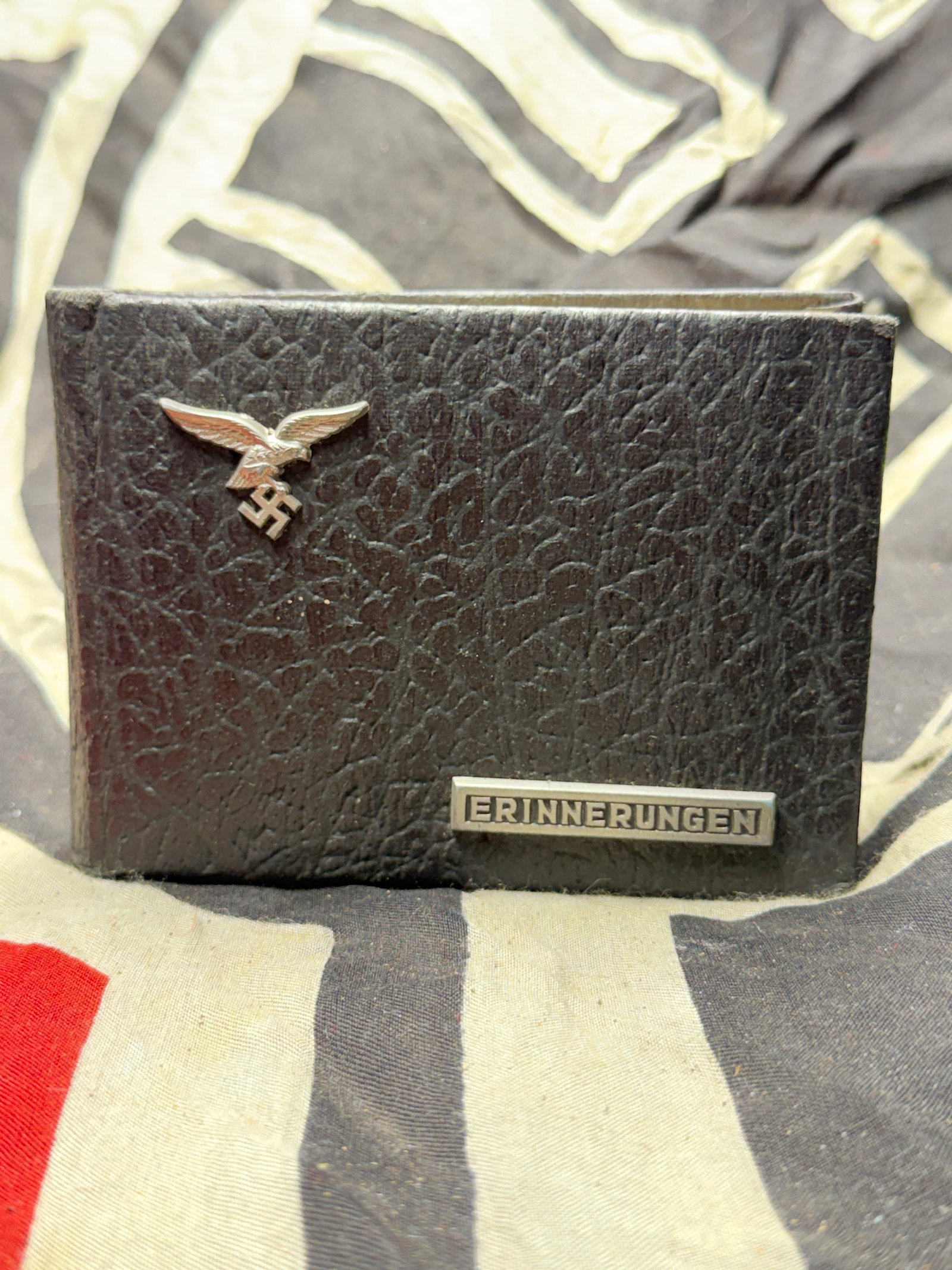 WW2 German Erinnerungen Memories Luftwaffe Photo Album: WW2 German Erinnerungen Memories Luftwaffe Photo Album. This compact leather-bound photo album, measuring approximately 5 inches (12.7 cm) across, bears two metal emblems: a Luftwaffe eagle clutching 