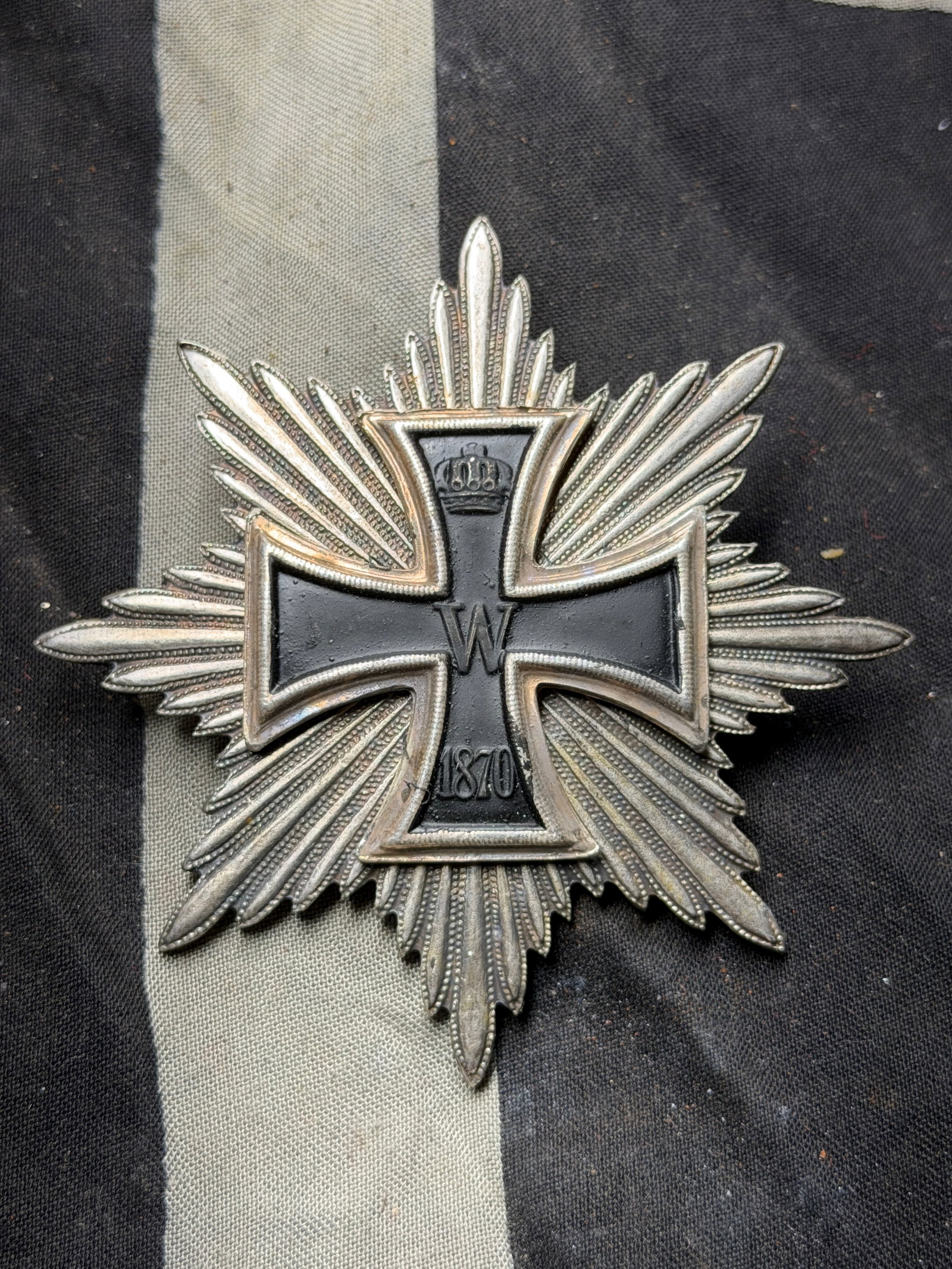 Prussian Order of the Iron Cross, 1st Class (Grand Cross Star) - Germany, 1870 Pattern By J. Wilm: This star-shaped decoration is a Prussian Iron Cross, 1st Class, 1870 version, mounted on a radiant silver starburst backing. At the center lies a black enamel Maltese cross bordered in silver, featur
