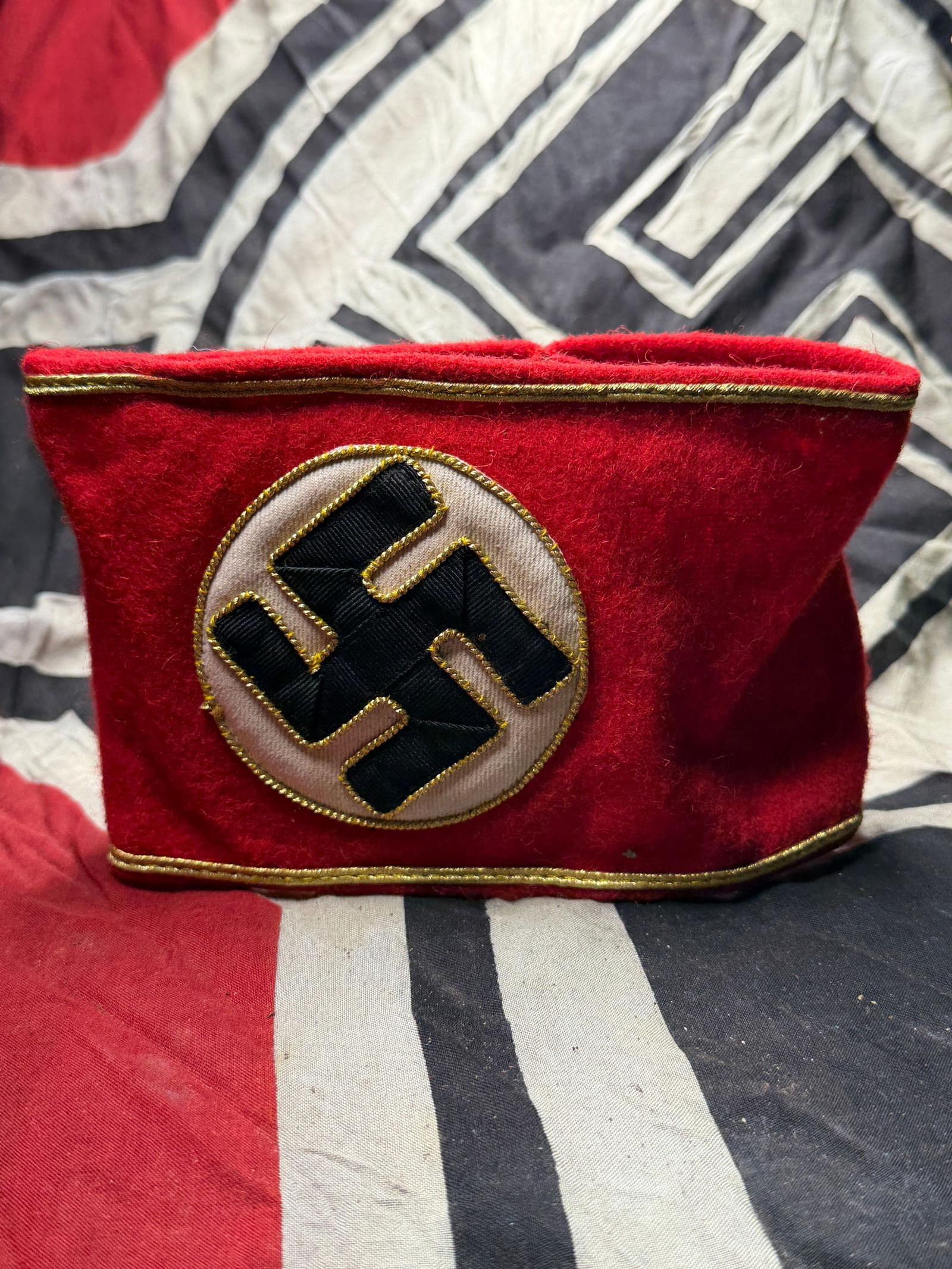 WW2 German Armband, National Socialist German Workers Party (NSDAP) With RZM Tag: WW2 German Armband, National Socialist German Workers Party (NSDAP) With RZM Tag. This red wool armband features a white circular field with a black hooked cross (swastika), outlined in gold piping, s