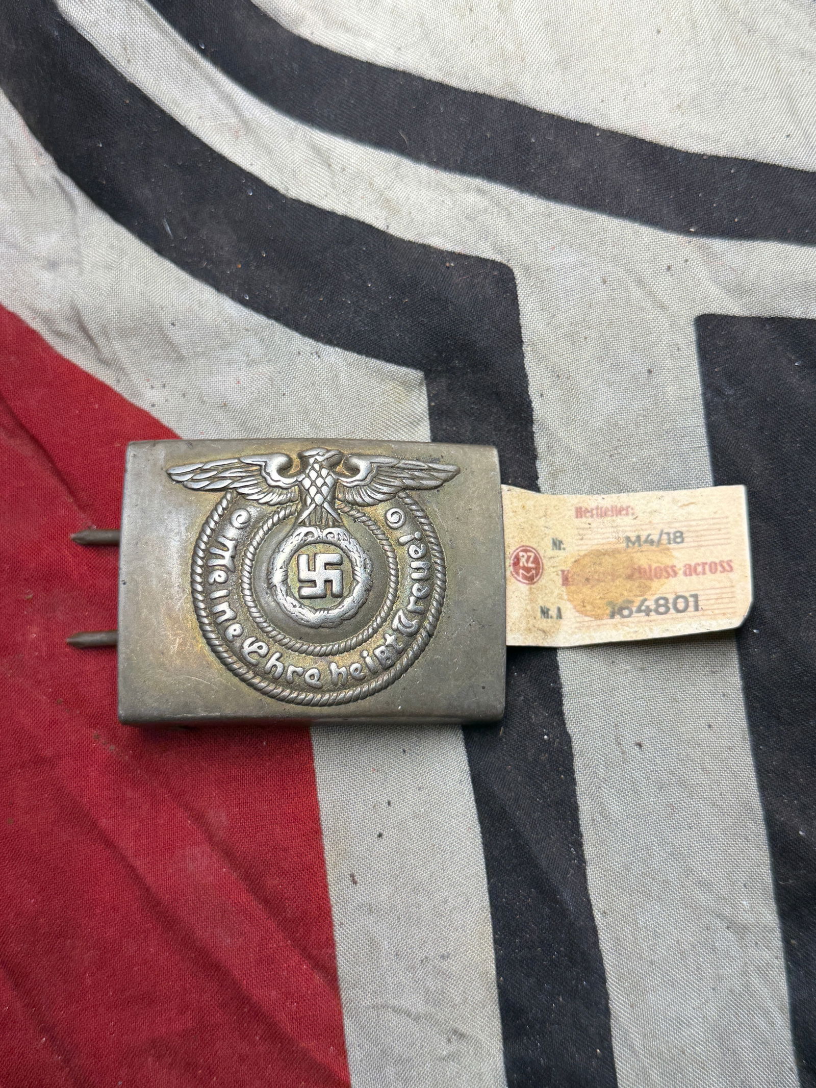 WW2 German SS Enlisted Man’s Belt Buckle ca. 1936–1945 With RZM Paper Tag: WW2 German SS Enlisted Man’s Belt Buckle ca. 1936–1945 With RZM Paper Tag. This is a steel SS enlisted man’s belt buckle, featuring the embossed design of the SS eagle clutching a swastika encir