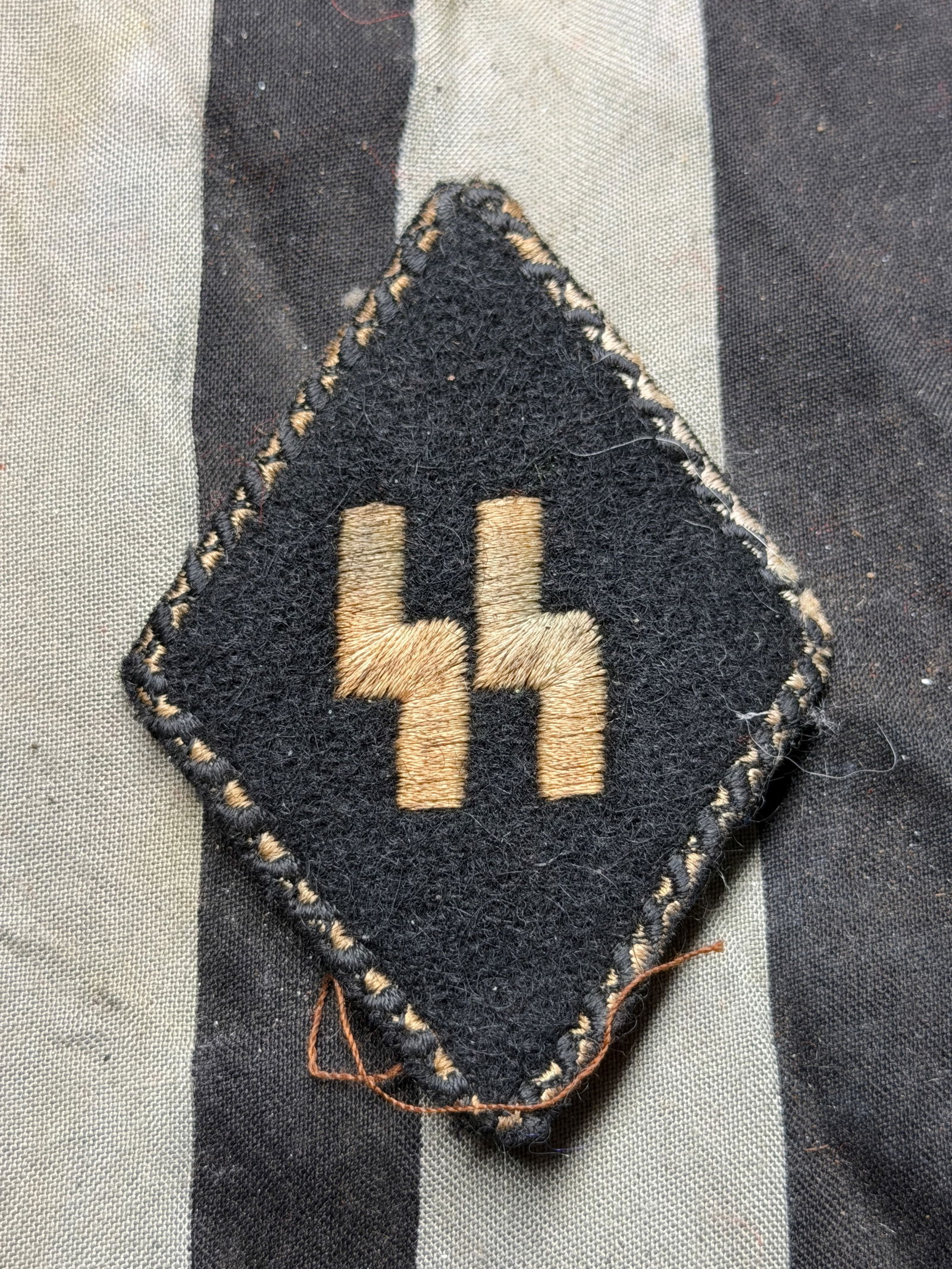 WW2 German Waffen-SS Diamond Shaped Collar Tab: WW2 German Waffen-SS Diamond Shaped Collar Tab. This artifact is a Waffen-SS collar tab, featuring the "SS" runic insignia, which identified membership in the Schutzstaffel (SS)—the paramilitary org