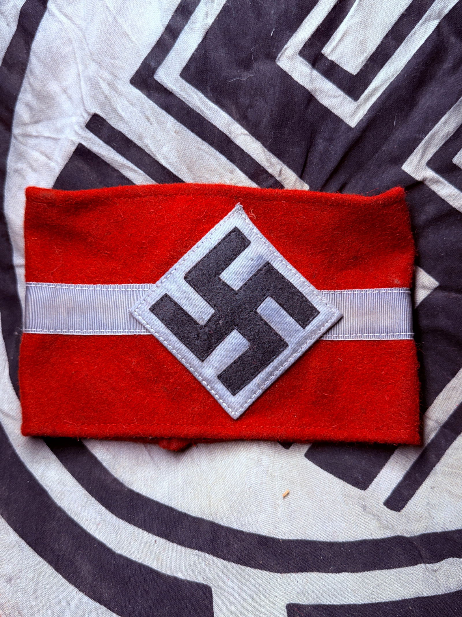 WW2 German Hitler Youth Armband (Hitlerjugend Armbinde), 1930s–1945 With RZM Paper Tag: WW2 German Hitler Youth Armband (Hitlerjugend Armbinde), 1930s–1945 With RZM Paper Tag. This red wool armband featuring a white diamond patch with a black swastika and a central white horizontal str