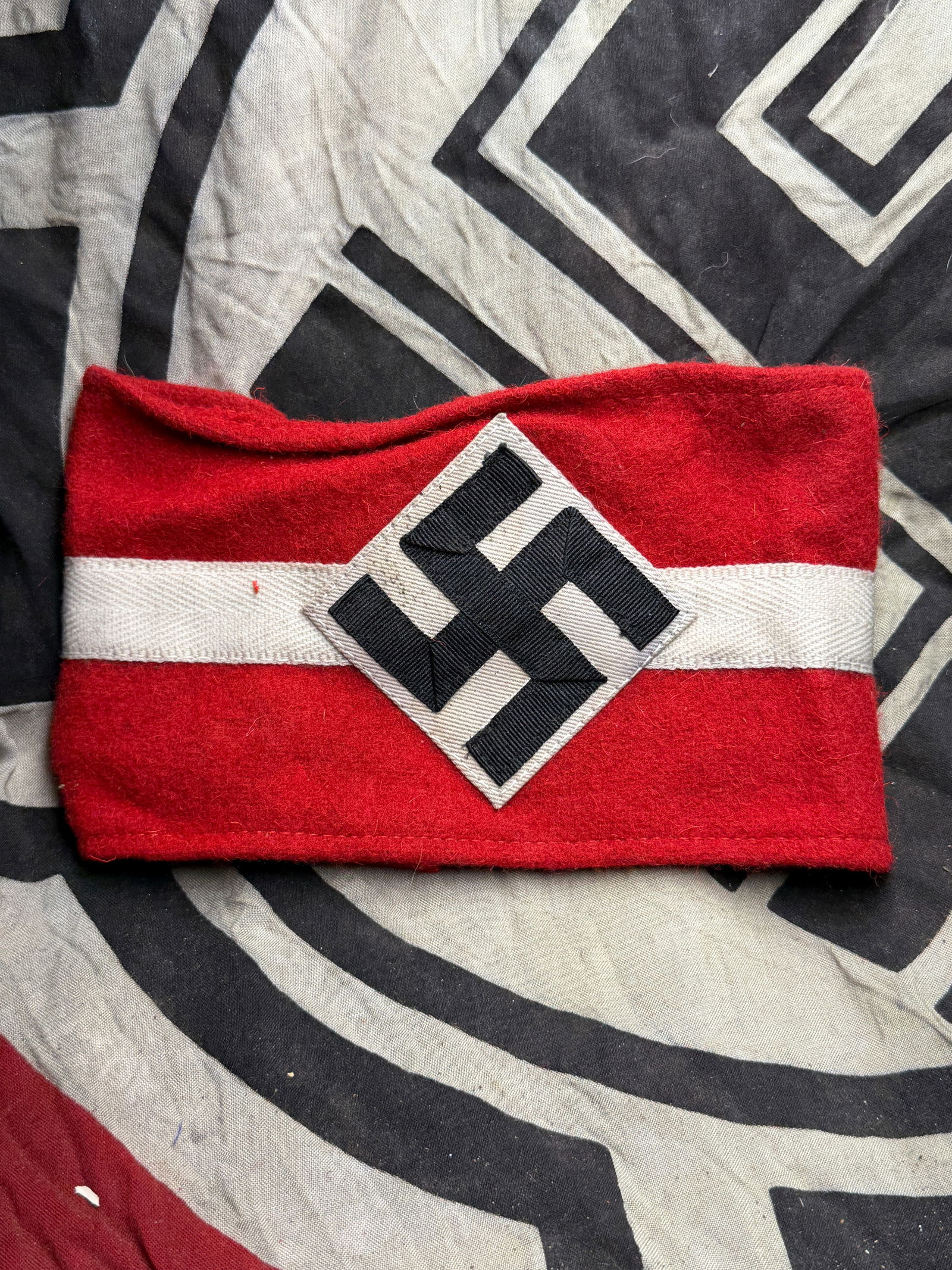 NSDAP National Socialist Armband, WW2 Germany, circa 1930s–1940s With RZM Paper Tag: This red wool armband features a white band and a black swastika within a white diamond patch. It was worn as part of the uniform of the National Socialist German Workers’ Party (NSDAP) during the p