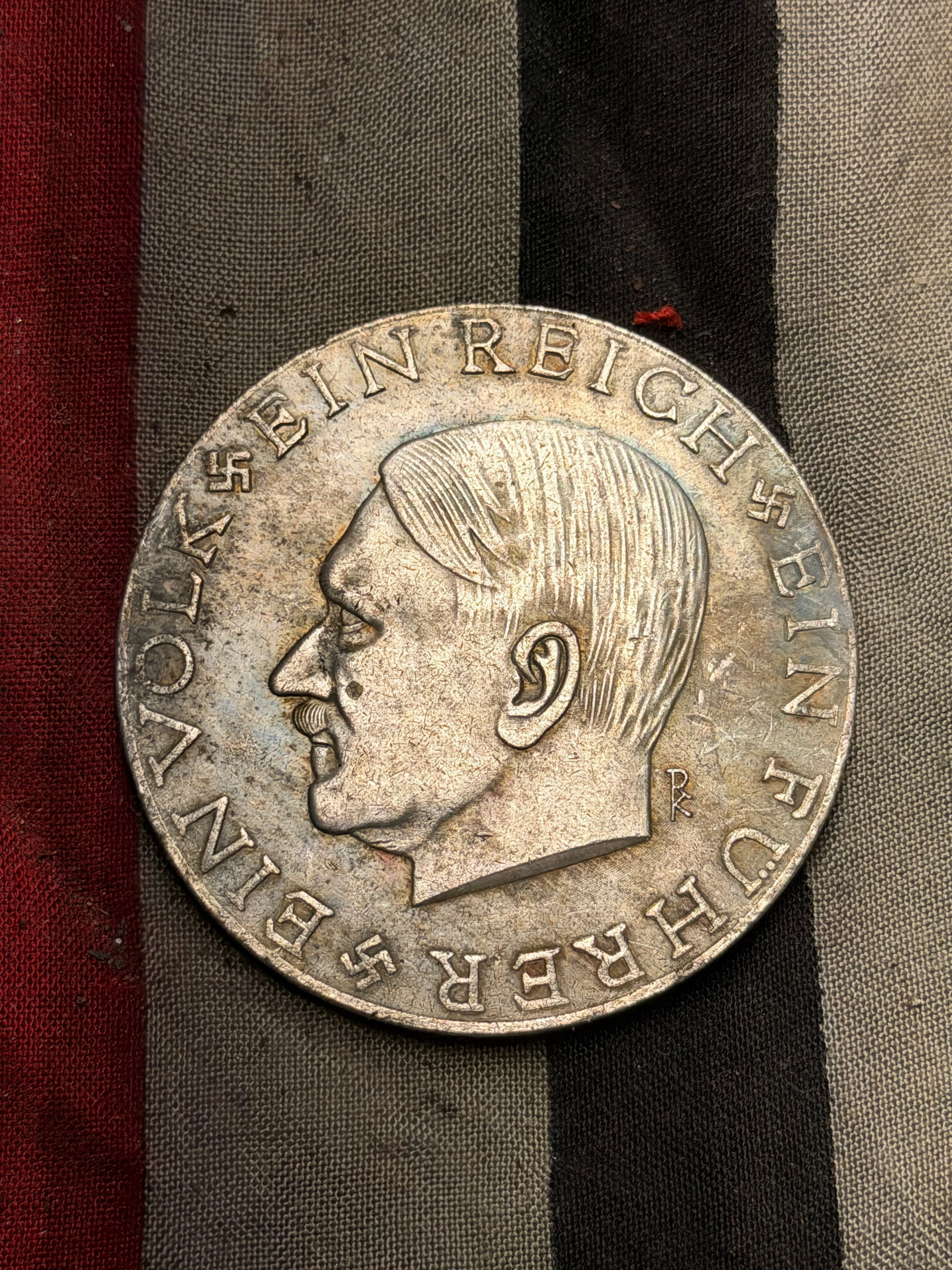 WW2 German Commemorative Silver Medal – “Grossdeutschland?? Referendum, 1938: This silver-colored commemorative medal was produced in 1938 to mark the Austrian Anschluss (annexation of Austria into Nazi Germany) and the German territorial expansion later that year. The obverse 