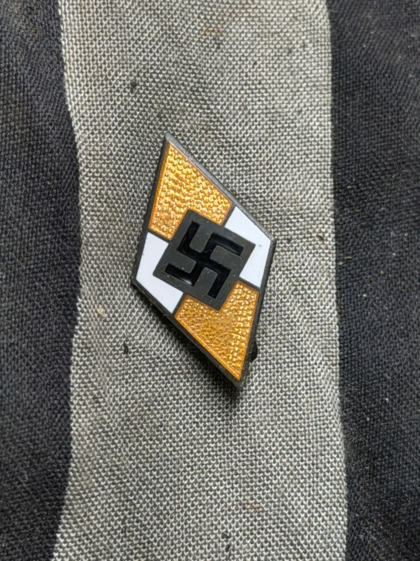 WW2 German Youth Organization Badge (Early to Mid-20th Century) By Otto Hoffmann, Ges. Gesch.: This is a metal and enamel badge in the form of a diamond, divided into white and gold fields with a central black symbol. The reverse bears a horizontal pin and is stamped “OTTO HOFFMANN, GES. GESC