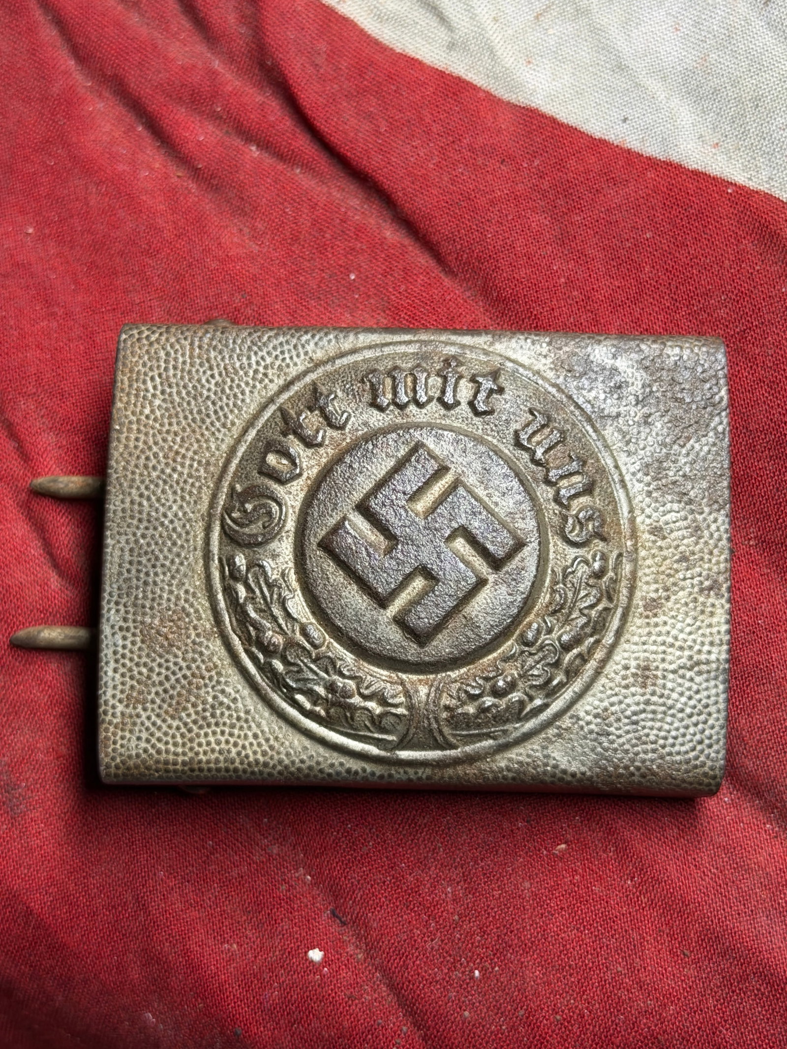 WWII German Army Belt Buckle – “Gott Mit Uns?? Pattern, Metal Construction: WWII-era German Army (Heer) belt buckle featuring the “Gott mit uns” (“God with us”) motto and central emblem surrounded by a wreath. The buckle is constructed of stamped metal, showin