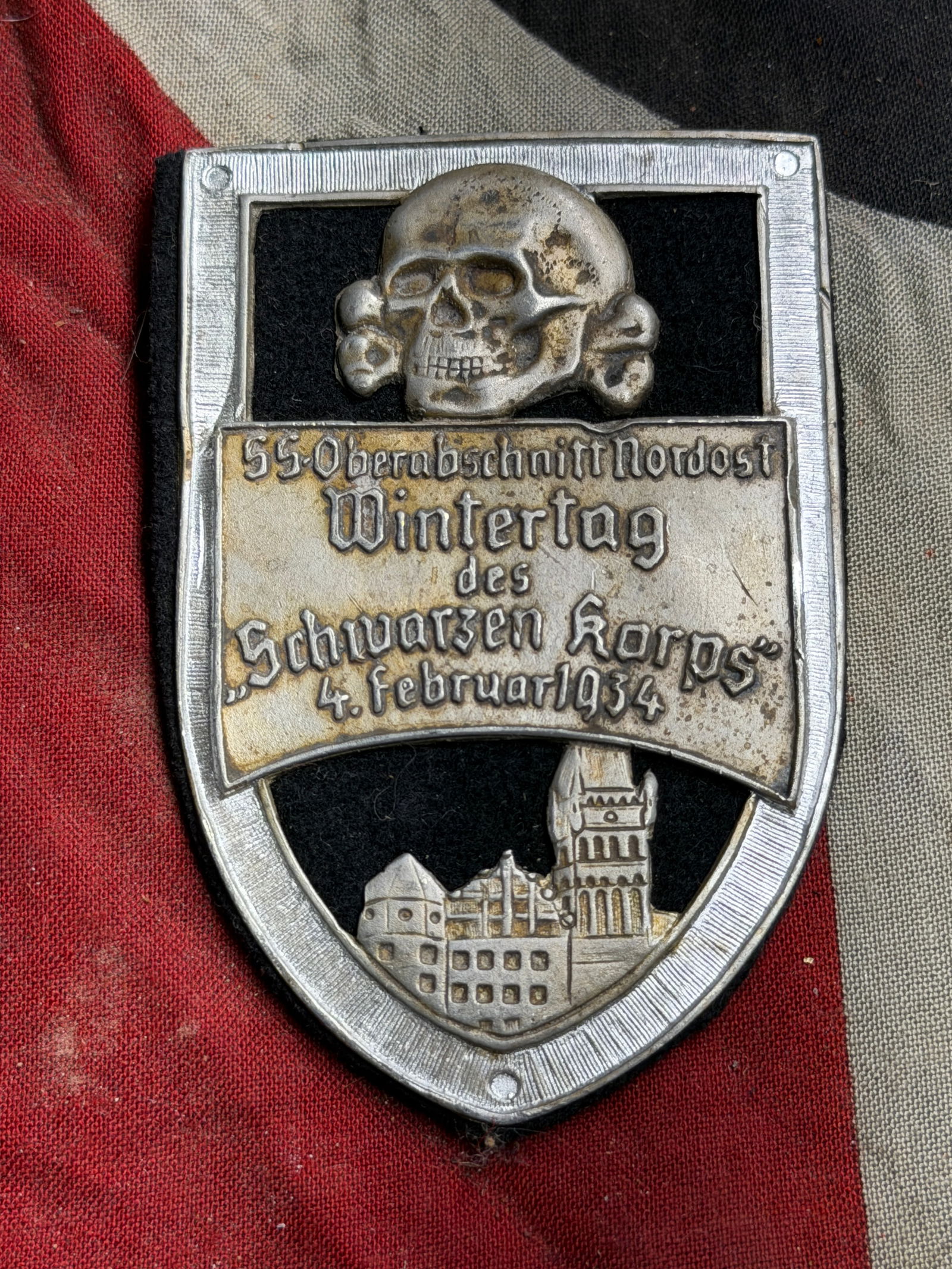 WW2 German Commemorative Badge – “Wintertag des Schwarzen Korps,?? 1934: This badge commemorates a gathering held in February 1934, referenced as the “Wintertag des Schwarzen Korps” (Winter Day of the Black Corps). It was produced for a regional organization event