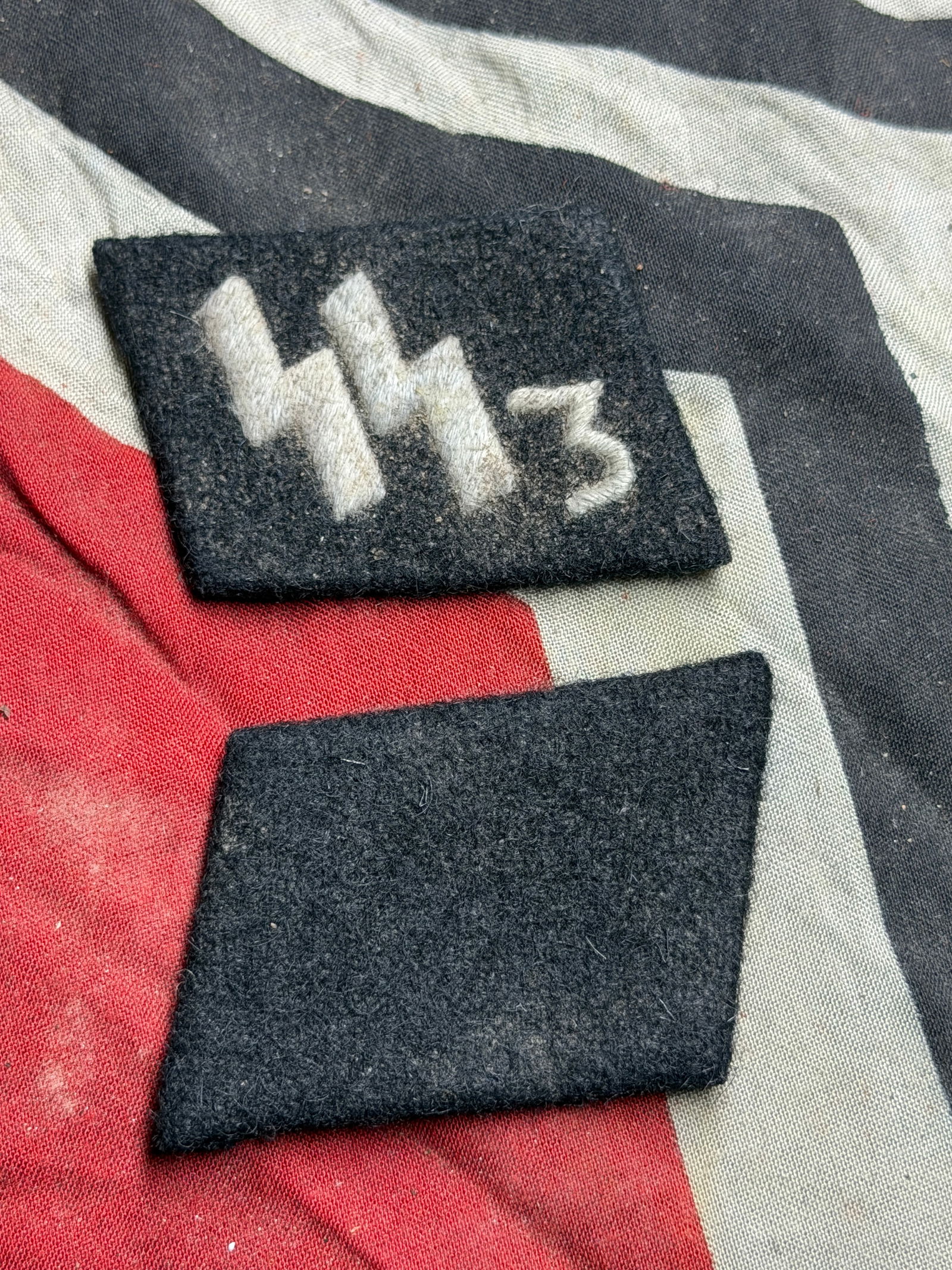 WW2 Pair Of German Waffen 3rd SS Division Uniform Collar Tabs (c. 1930s–1940s) With RZM Paper Tag: These collar tabs are examples of insignia used on German uniforms during the 1930s and 1940s. Constructed from black wool with burlap backing, the set includes one tab bearing embroidered runic symbo
