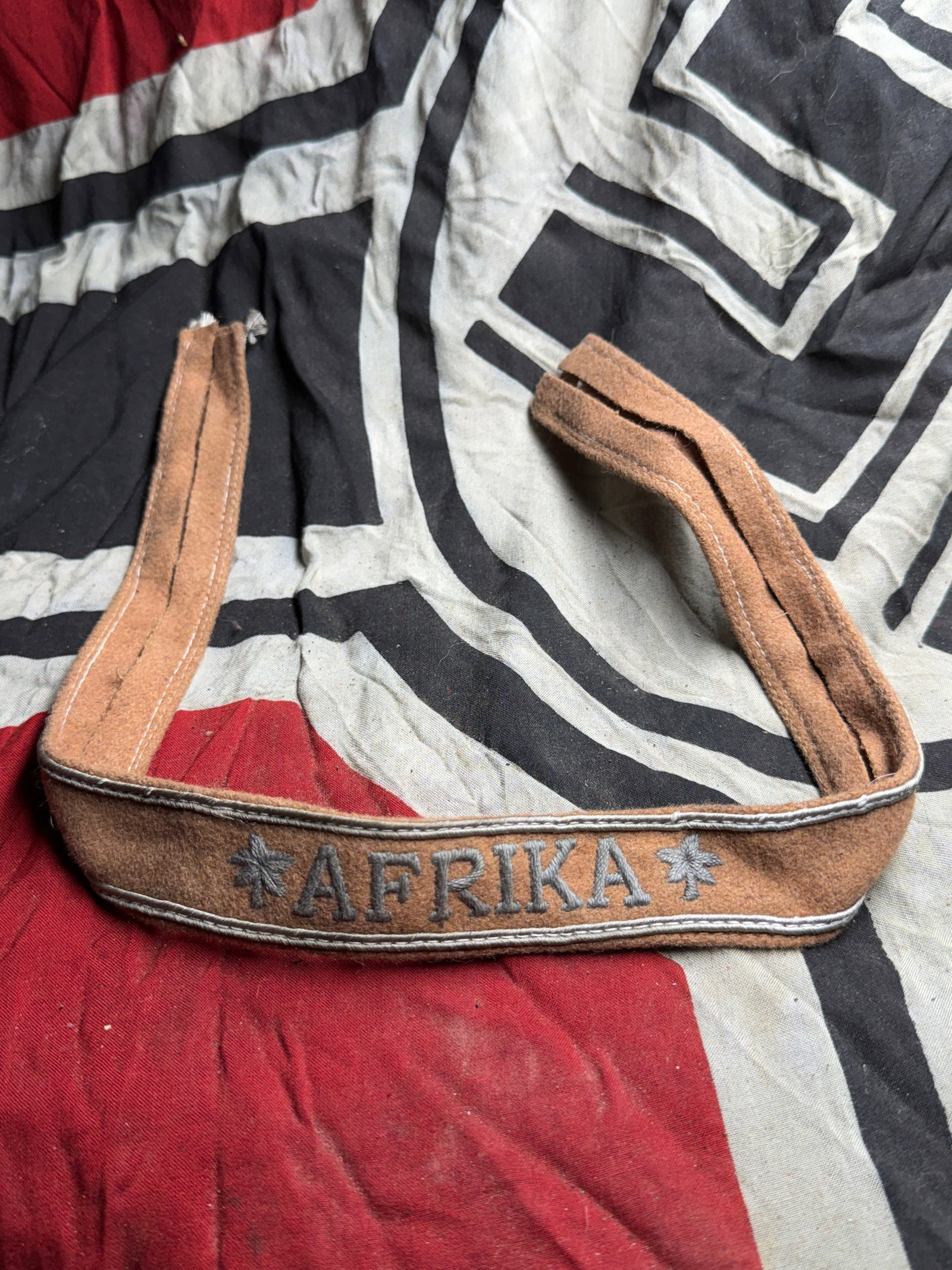 WW2 German Afrika Campaign Cuff Title (Afrikakorps), 1941–1943: This tan cloth cuff title, embroidered with the word “Afrika” flanked by palm tree motifs, was awarded to members of the Afrika Korps and other German units who served in the North African cam