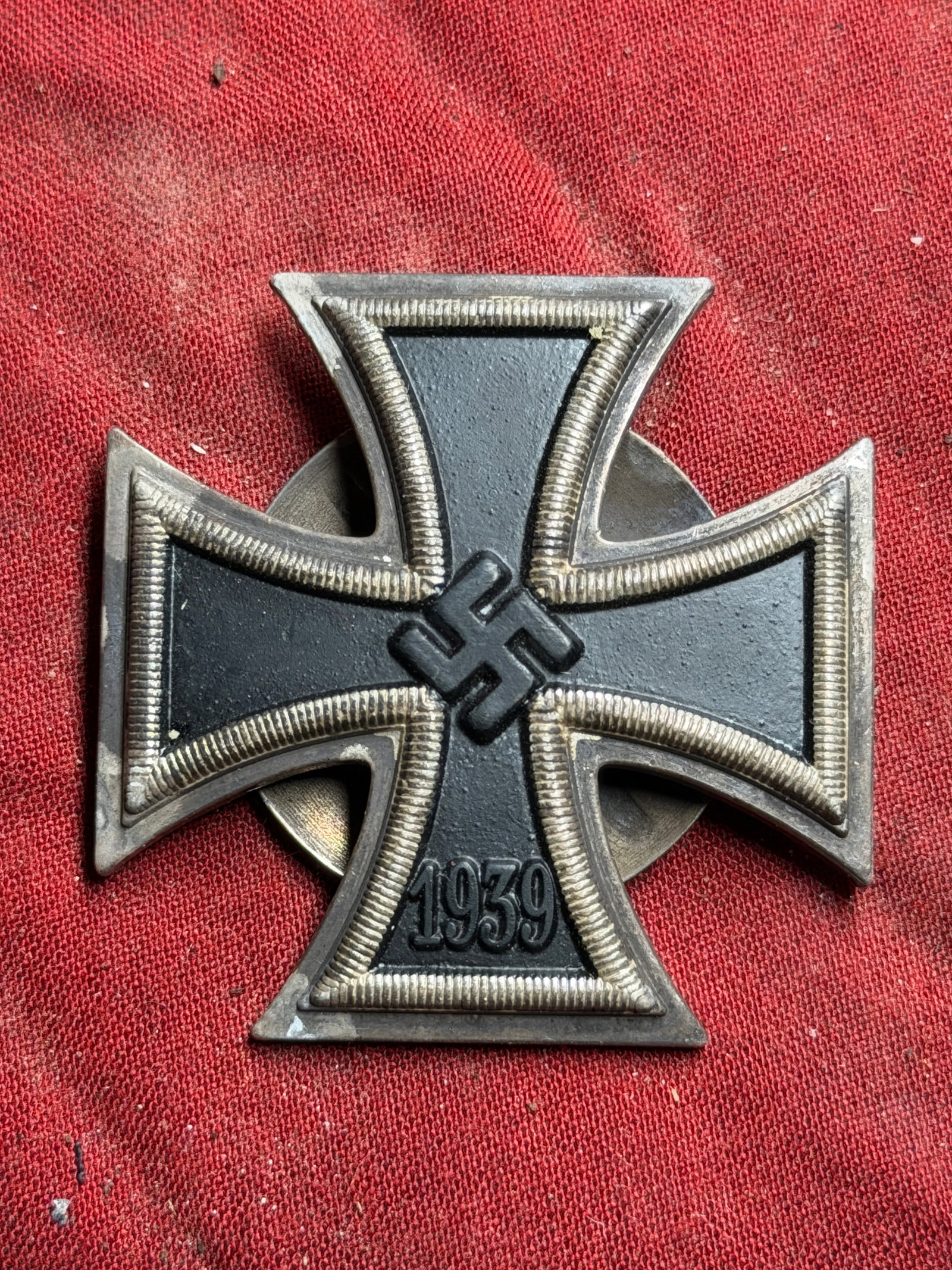 WW2 German Iron Cross, 2nd Class, 1939 (Eisernes Kreuz II. Klasse): This is an example of the Iron Cross, a German military decoration re-instituted in 1939. The cross design, with a blackened iron core framed in silver, dates back to its original introduction during 