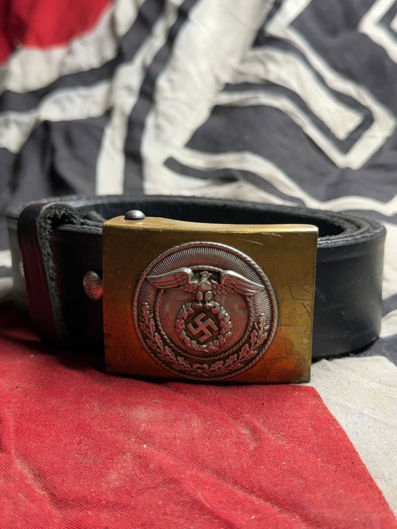 SCARCE WW2 GERMAN SA BUCKLE WITH LEATHER BELT: SCARCE WW2 GERMAN SA BUCKLE WITH LEATHER BELT. This item consists of a black leather belt fitted with a brass buckle featuring a national eagle design above a wreath. Such belts were part of the stand