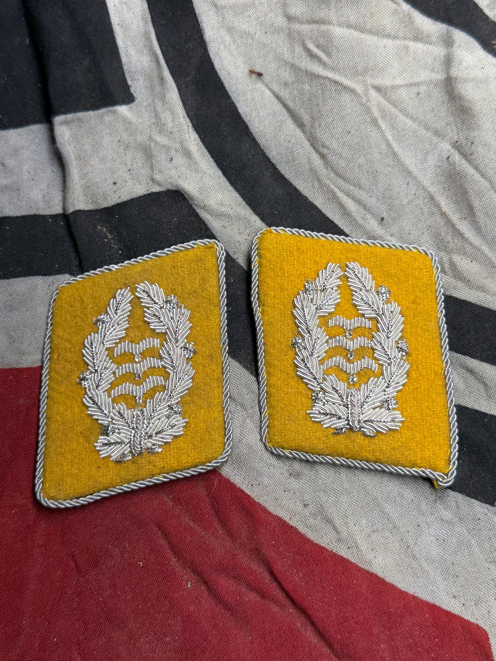 WWII German Luftwaffe Flieger Division Oberst Collar Tabs Yellow With RZM Paper Tag: WWII German Luftwaffe Flieger Division Oberst Collar Tabs Yellow With RZM Paper Tag. This matching pair of yellow wool collar tabs features finely hand-embroidered silver bullion oak leaf wreaths surr