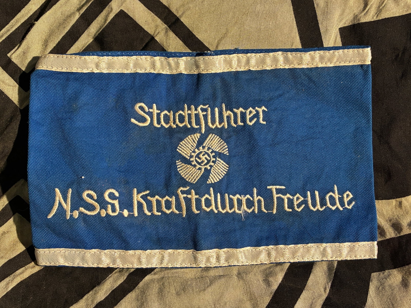 WW2 German Armband of a City Leader, “Kraft durch Freude?? (Strength Through Joy): This blue cloth armband belonged to a Stadtführer (“City Leader”) within the Nationalsozialistische Gemeinschaft Kraft durch Freude (N.S.G. KdF), or “Strength Through Joy,” a mass lei