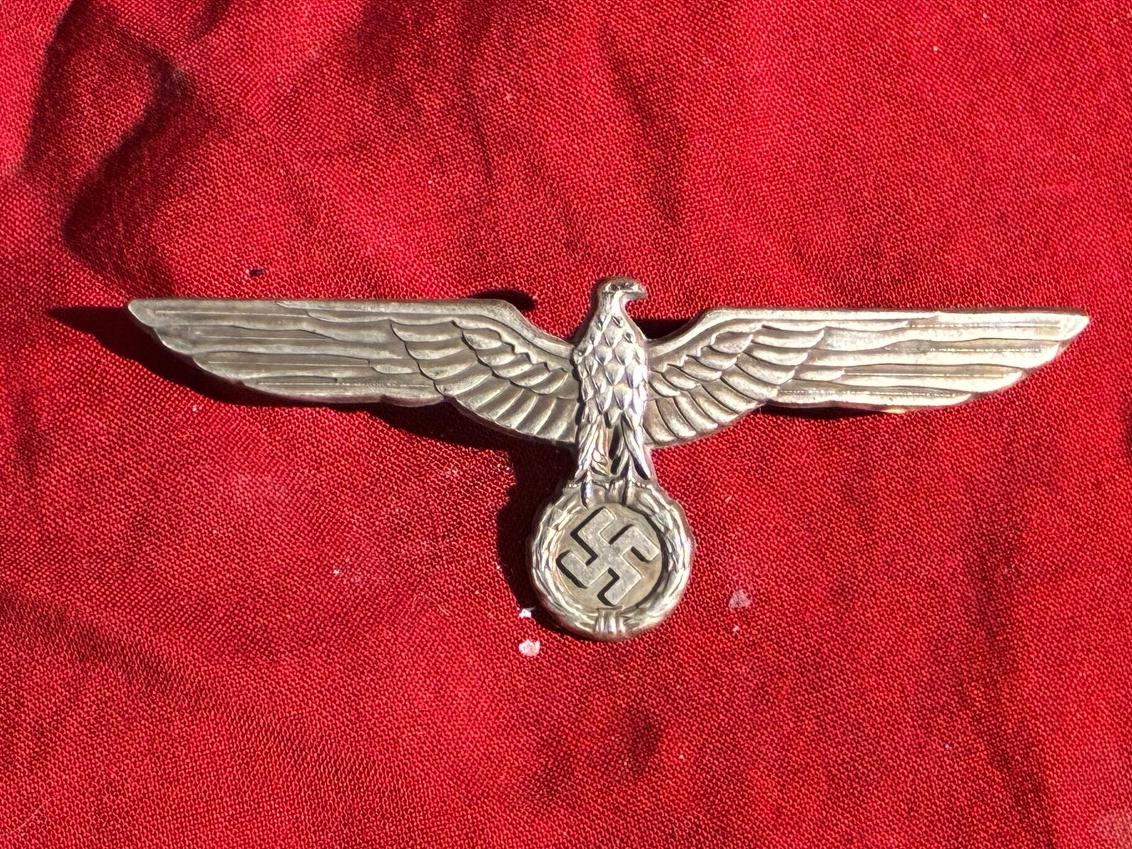 WWII GERMAN ARMY OFFICERS WHITE SUMMER TUNIC BREAST EAGLE BY ASSMANN: WWII GERMAN ARMY OFFICERS WHITE SUMMER TUNIC BREAST EAGLE. ALUMINUM CONSTRUCTION. MEASURES 3 3/4? FROM WING TIP TO WING TIP. GOOD PIN BACK WITH HOOK CATCH. SHOWS USE AND WEAR WITH SOME DINGS AND CORRO