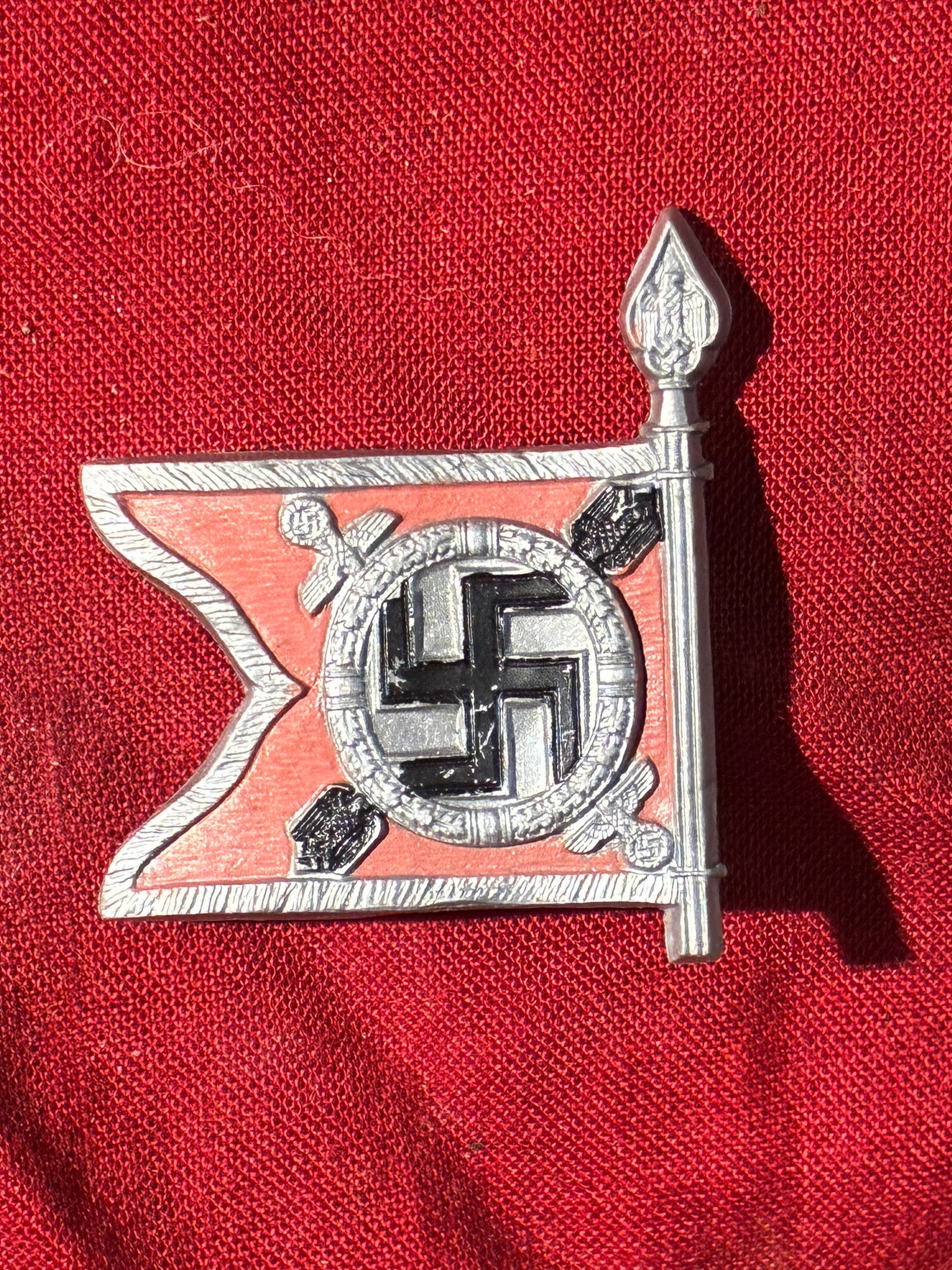 WW2 German Commemorative Badge of the Führerbegleitbataillon (Führer Escort Battalion): This small, die-struck metal badge represents a stylized unit standard of the Führerbegleitbataillon—the elite military formation assigned to provide close security and ceremonial escort for Adolf 