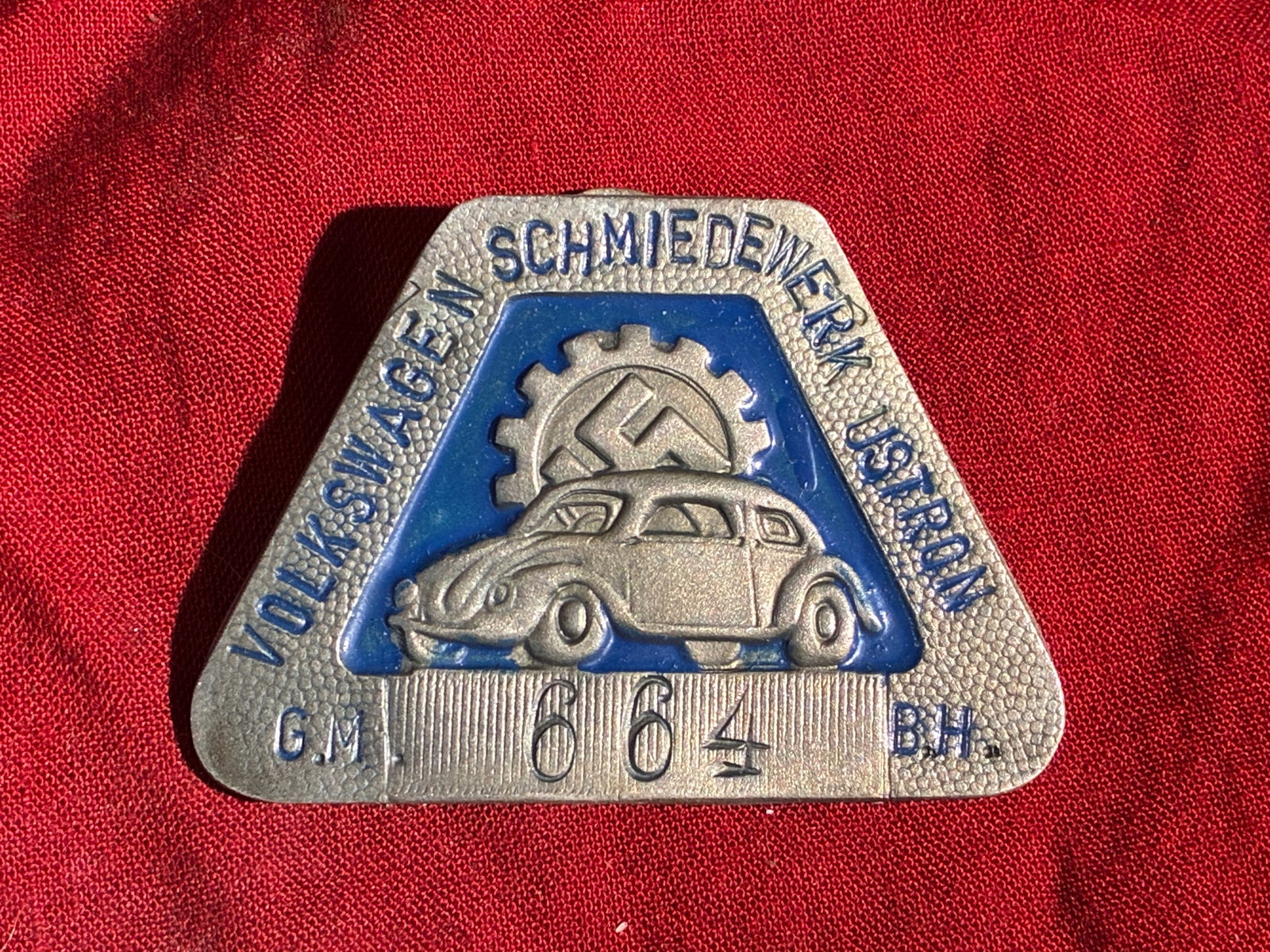 WW2 German Volkswagen Schmiedeberg Worker’s Badge (c. late 1930s–1940s): This small triangular metal badge was issued to workers at the Volkswagen Schmiede-Werk (Volkswagen Forge Works), part of the early German automotive manufacturing network during the late 1930s and ea