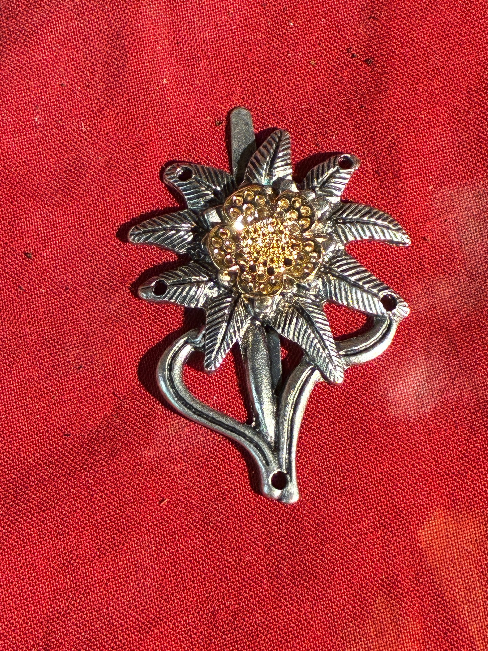 WW2 German Decorative Edelweiss Mount with Gilt Floral Center: WW2 German Decorative Edelweiss Mount with Gilt Floral Center. A rare find. Shows good wear and use with a beautiful overall patina. Please view all detailed pictures. A scarce example of the time per