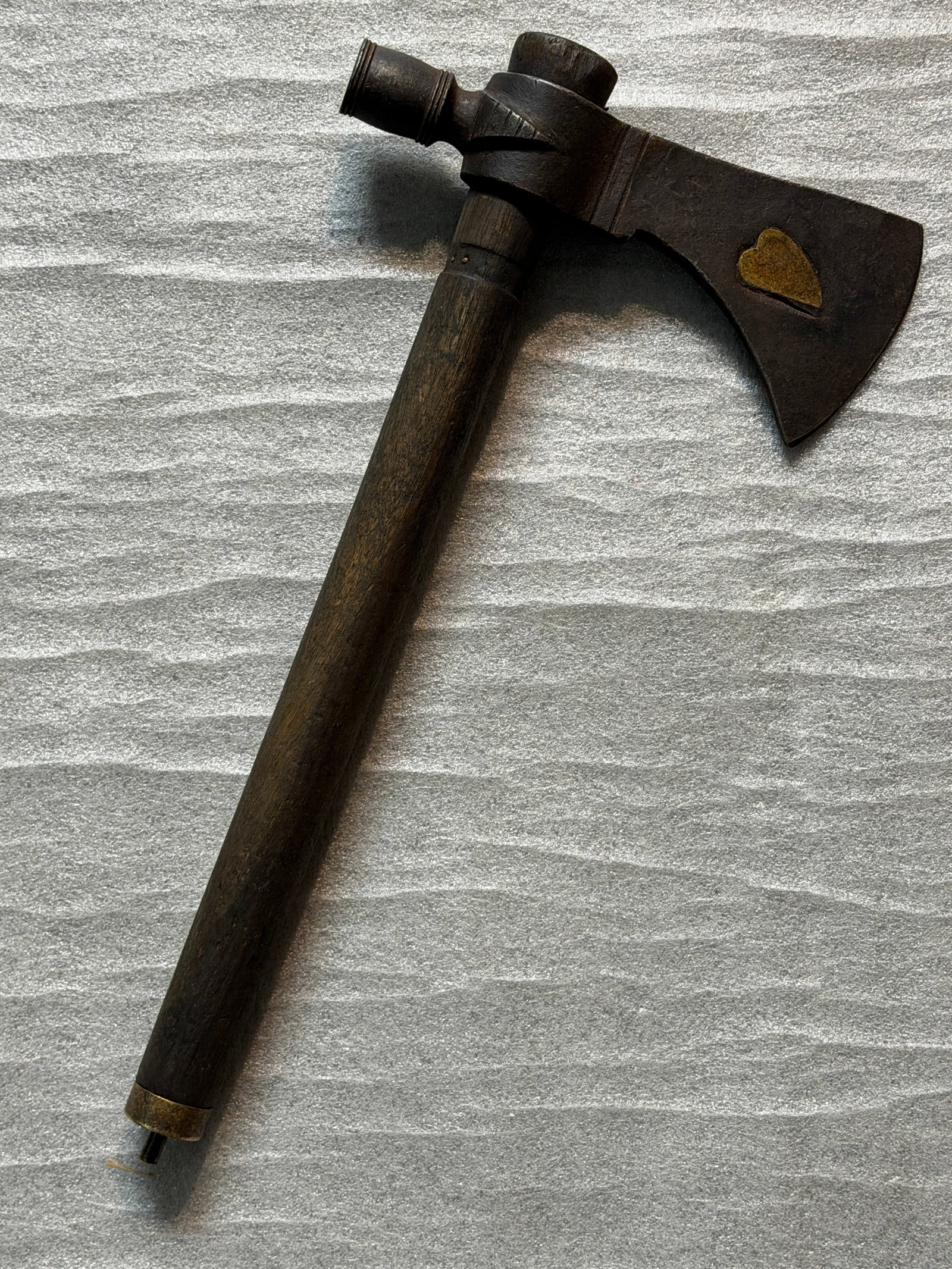 18th–19th C. Native American Plains Indians Pipe Tomahawk with Heart-Inlaid Blade: his finely crafted pipe tomahawk represents one of the most iconic intercultural objects of the North American frontier, blending both weapon and ceremonial pipe into a single form. Originating in the