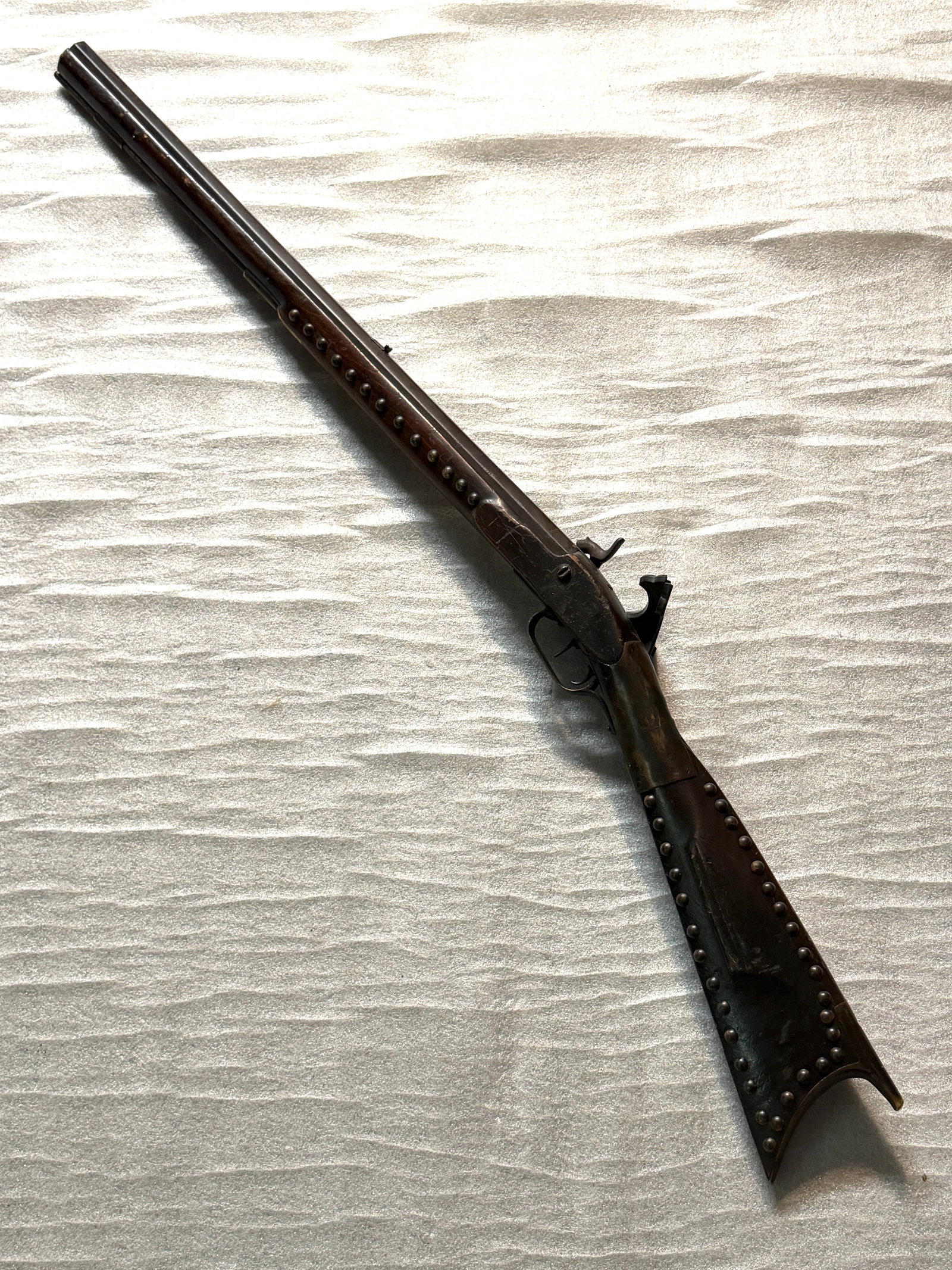 Plains Indian–Modified Trade Musket with Tack Decoration, ca. 1860–1880: This heavily adorned Plains Indian–modified trade musket represents the deep cultural adaptation and artistry that Native nations across the Northern Plains—particularly the Lakota, Cheyenne, and 