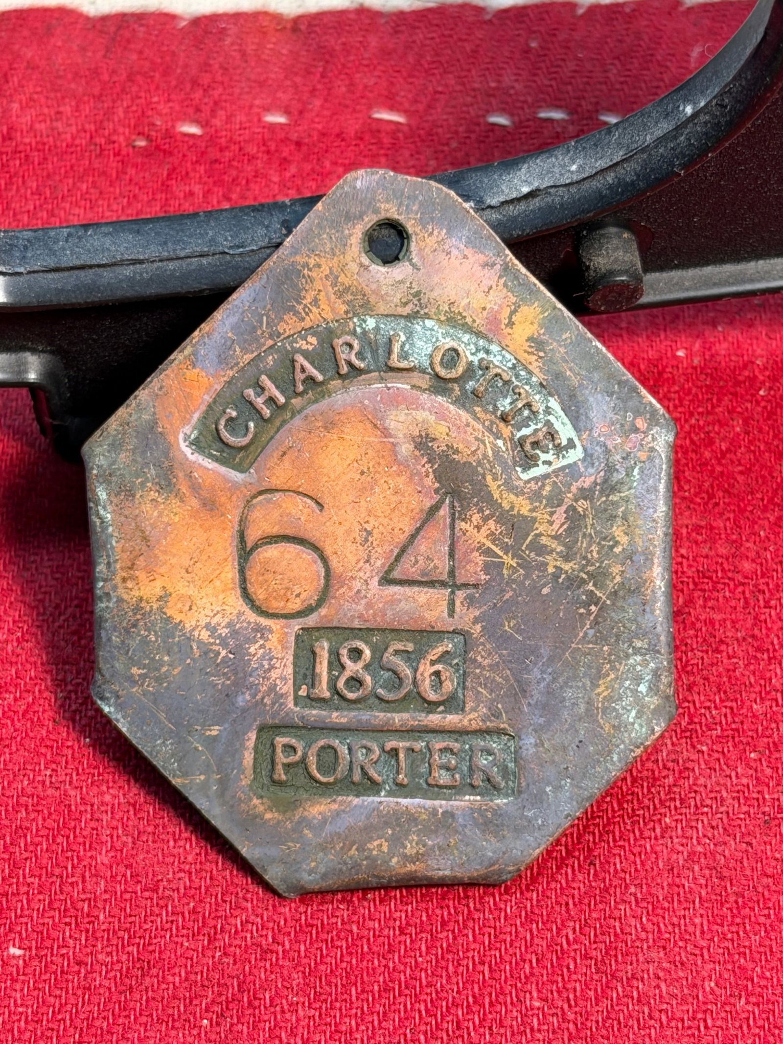 1856 Charlotte Slave Tag – Porter No. 64 (Servant Identification Badge): This octagonal brass identification badge, stamped “CHARLOTTE,” “1856,” “PORTER,” and numbered 64, is an original pre–Civil War slave tag, a mandatory form of identification 