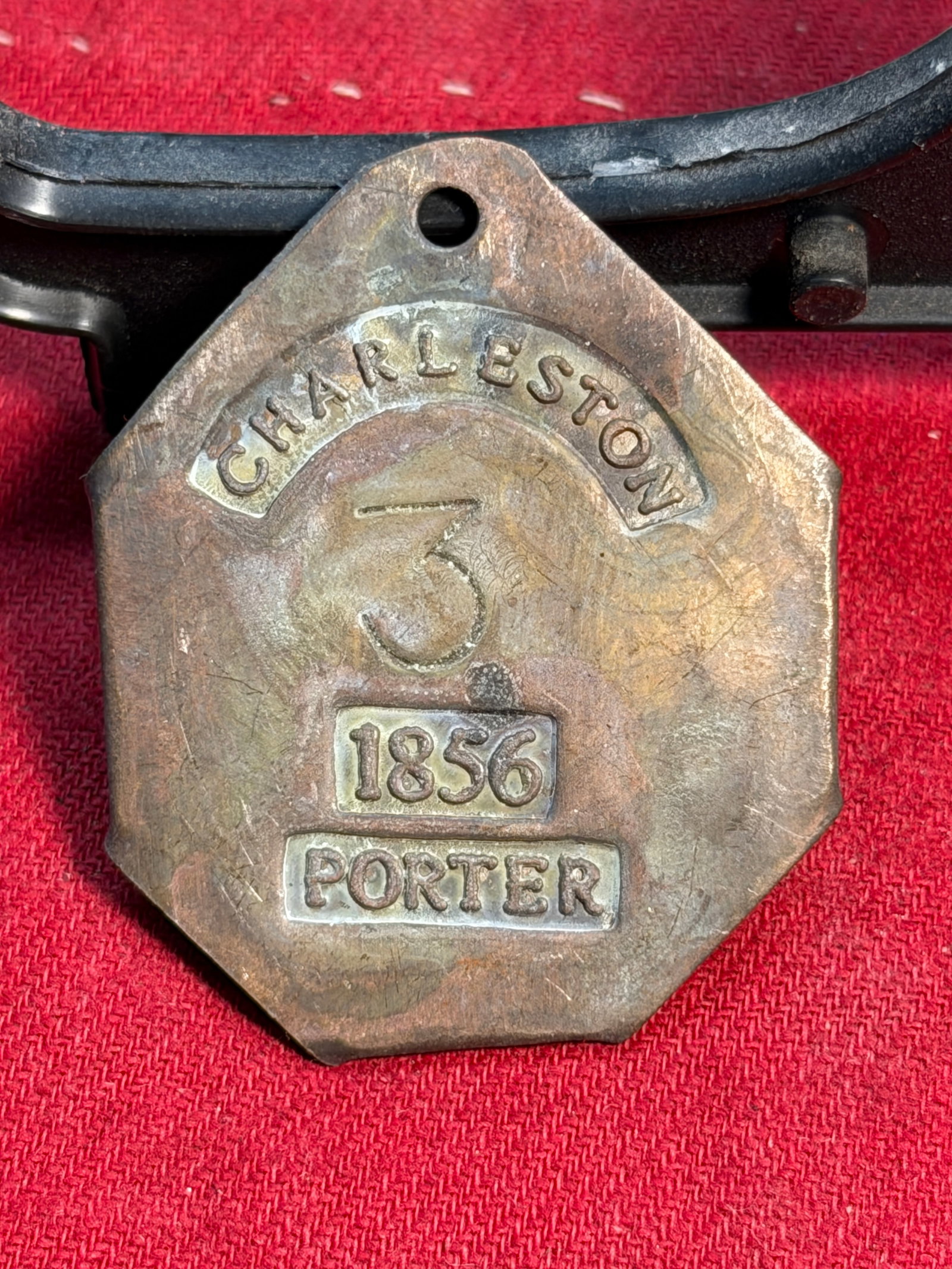 1856 Charleston Slave Tag – Porter No. 3: This rare 1856 Charleston slave tag, stamped PORTER and bearing the number 3, is an original identification badge once worn by an enslaved laborer in Charleston, South Carolina. Slave tags—also know