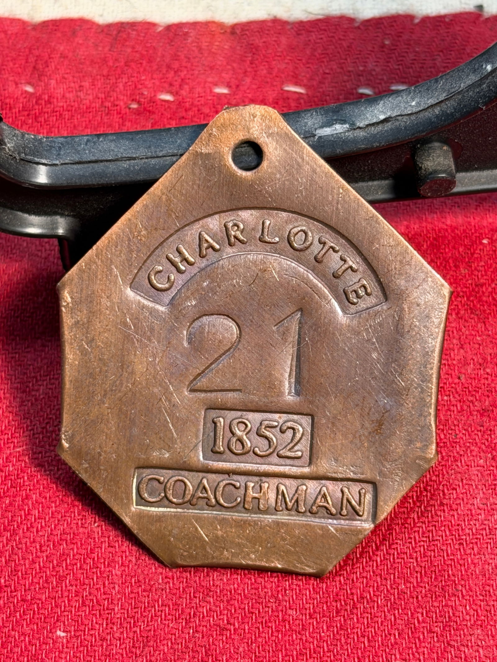 1852 Charlotte Coachman Slave Tag – Servant Identification Badge No. 21: This rare copper identification tag, stamped “CHARLOTTE”, “1852”, “COACHMAN”, and bearing the number 21, is an original slave tag used in mid-19th-century Charlotte, North Caro