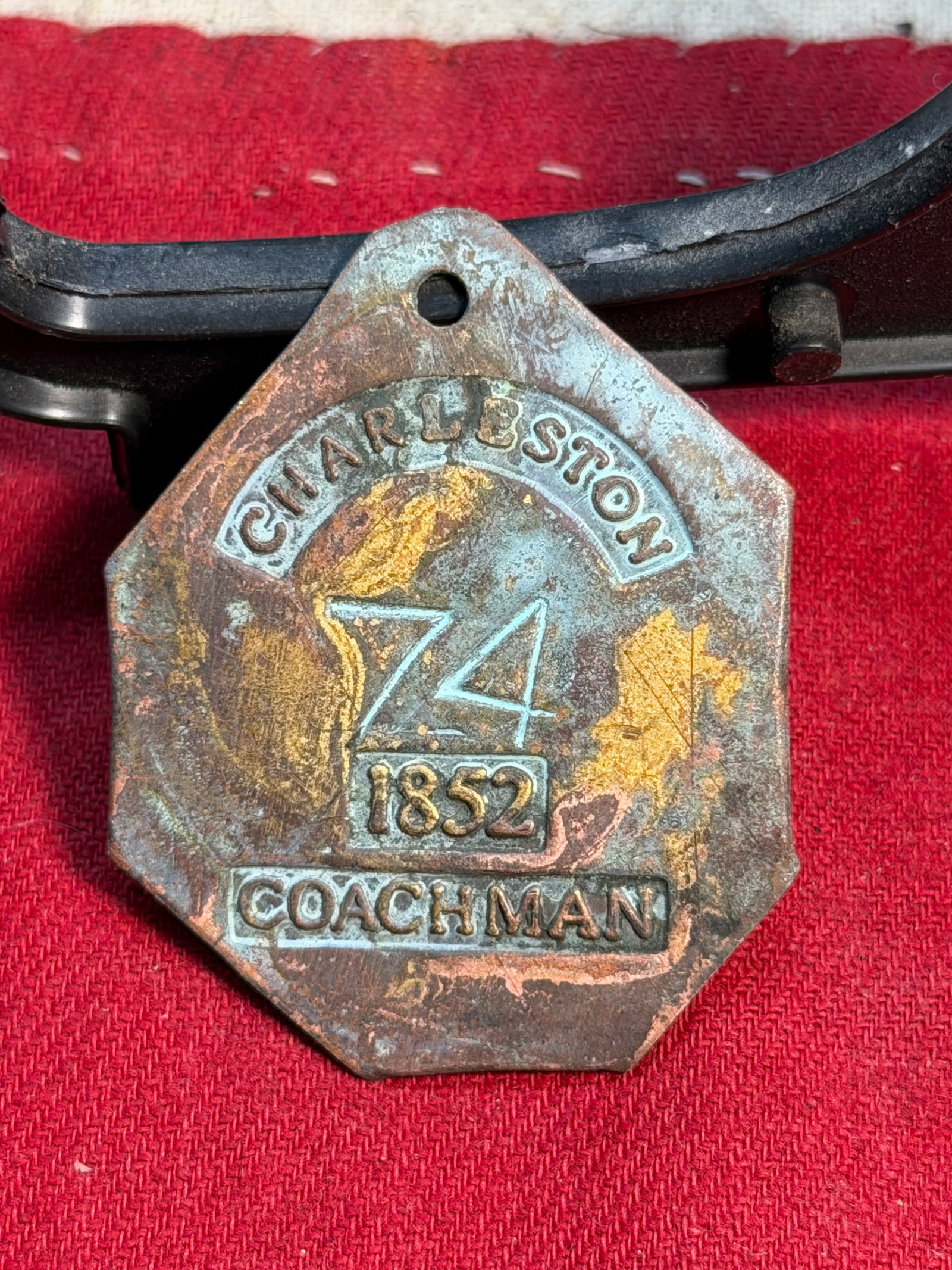 1852 Charleston Coachman Slave Tag – Enslaved Servant Identification Badge #74: This octagonal copper-alloy identification tag, numbered 74 and dated 1852, was issued in Charleston, South Carolina, to an enslaved coachman. Such tags, commonly called slave tags or servant badges, 