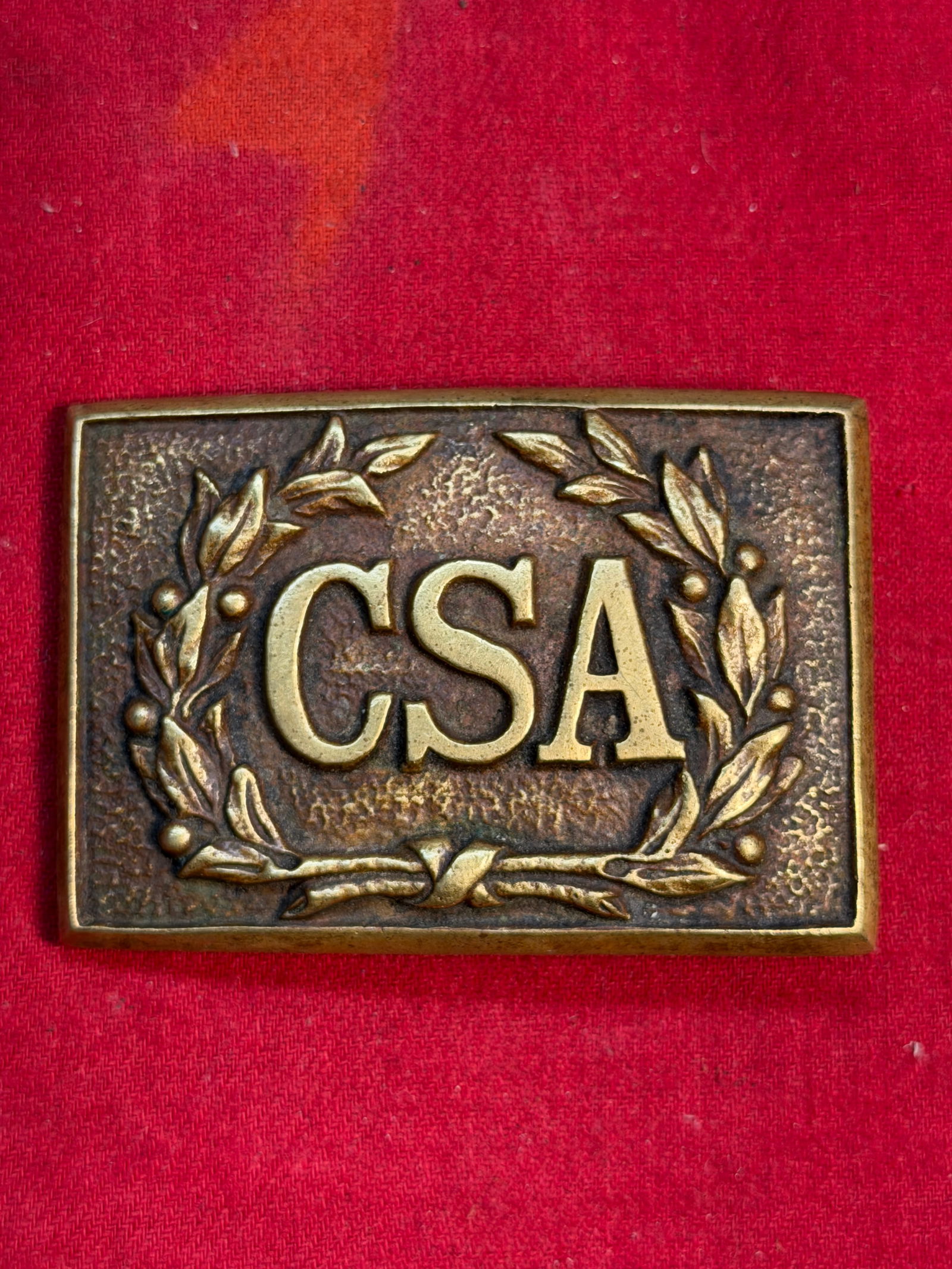 Civil War Confederate States Army (CSA) Rectangular Waist Belt Plate: This rectangular brass belt plate, embossed with the bold letters “CSA” surrounded by a laurel wreath, represents the standard insignia used by soldiers of the Confederate States Army during t