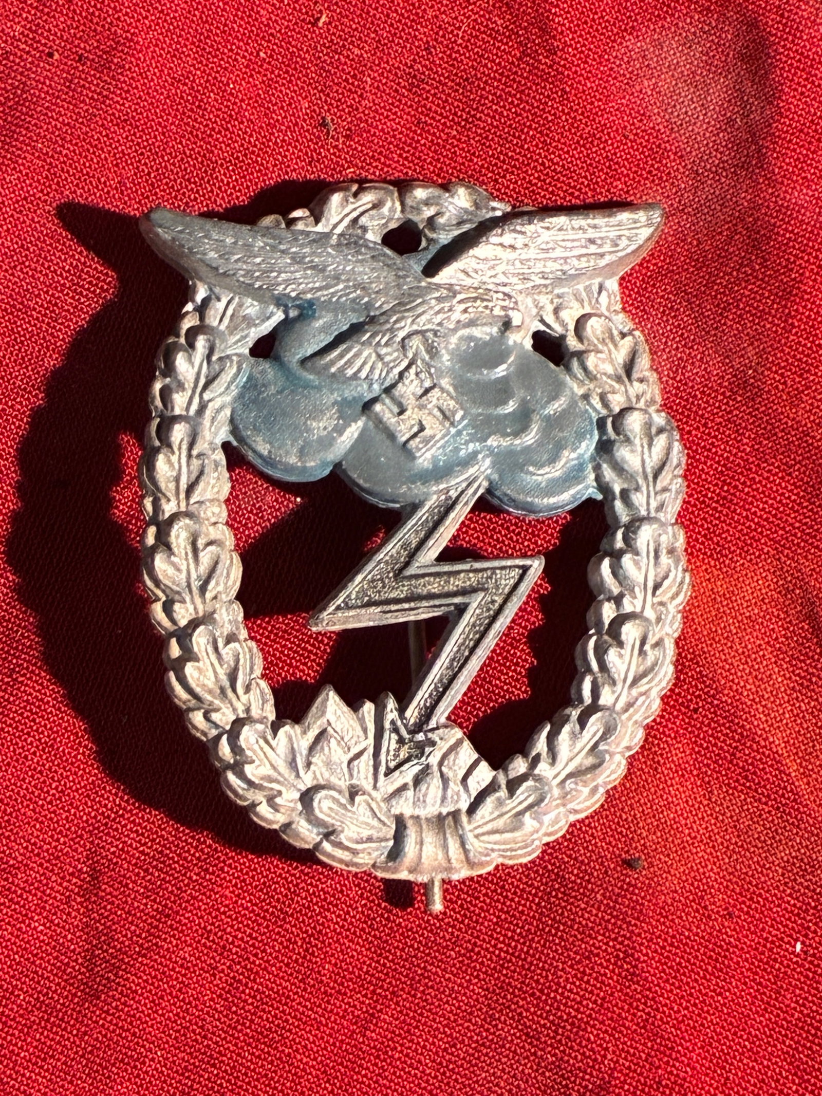 Luftwaffe Ground Assault Badge (Erdkampfabzeichen), WW2 Germany, 1942–1945 By CE Juncker Berlin SW: This military qualification badge was issued to members of the German Luftwaffe during the Nazi era for participation in ground-combat operations. The design features a silvered wreath of oak leaves s