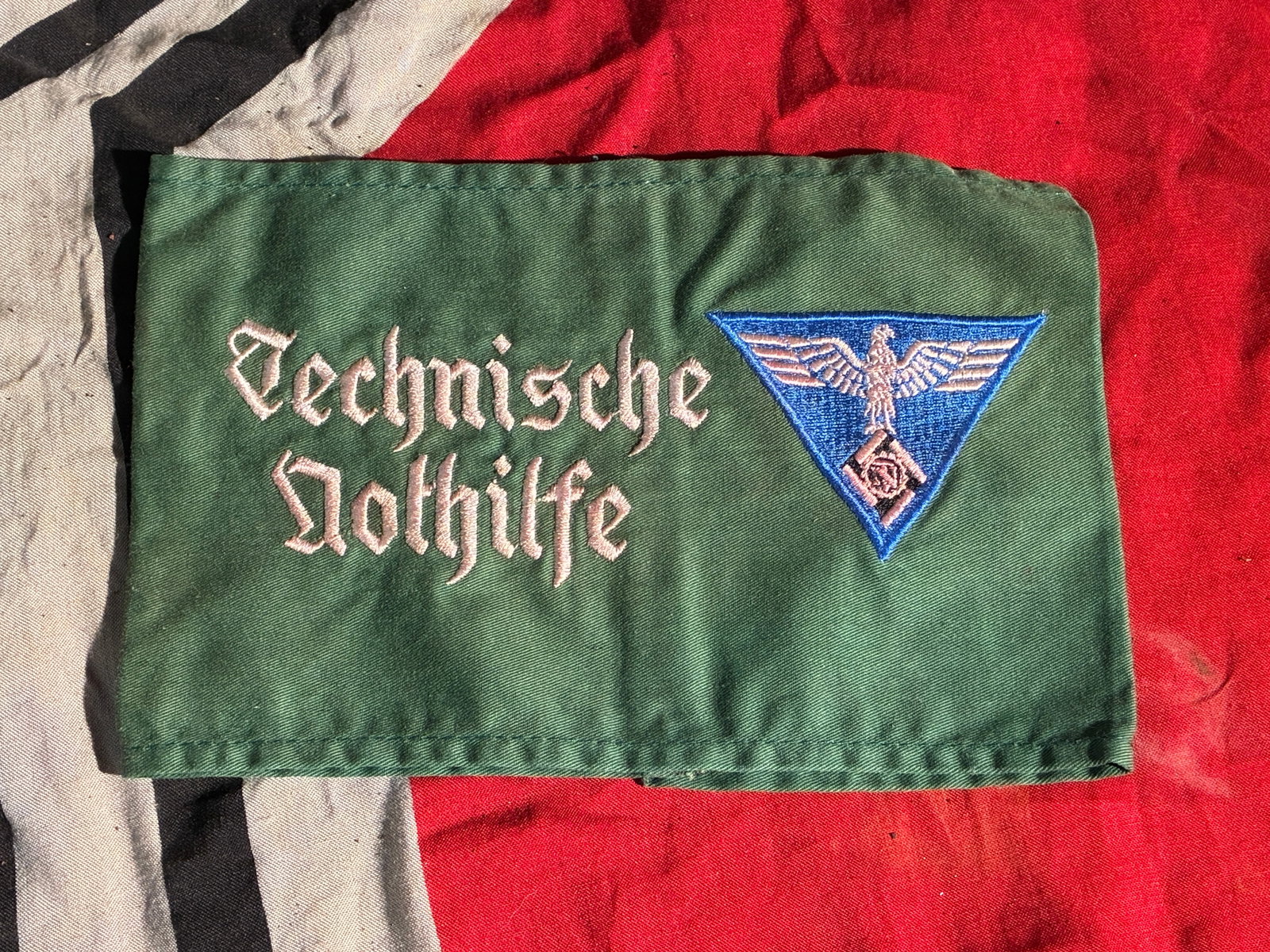 Technische Nothilfe (TeNo) Identification Armband, WW2 Germany, c. 1930s–1945: This green cloth armband, embroidered with the name “Technische Nothilfe” (“Technical Emergency Assistance”) and the organization’s triangular emblem, belonged to a member of the TeN