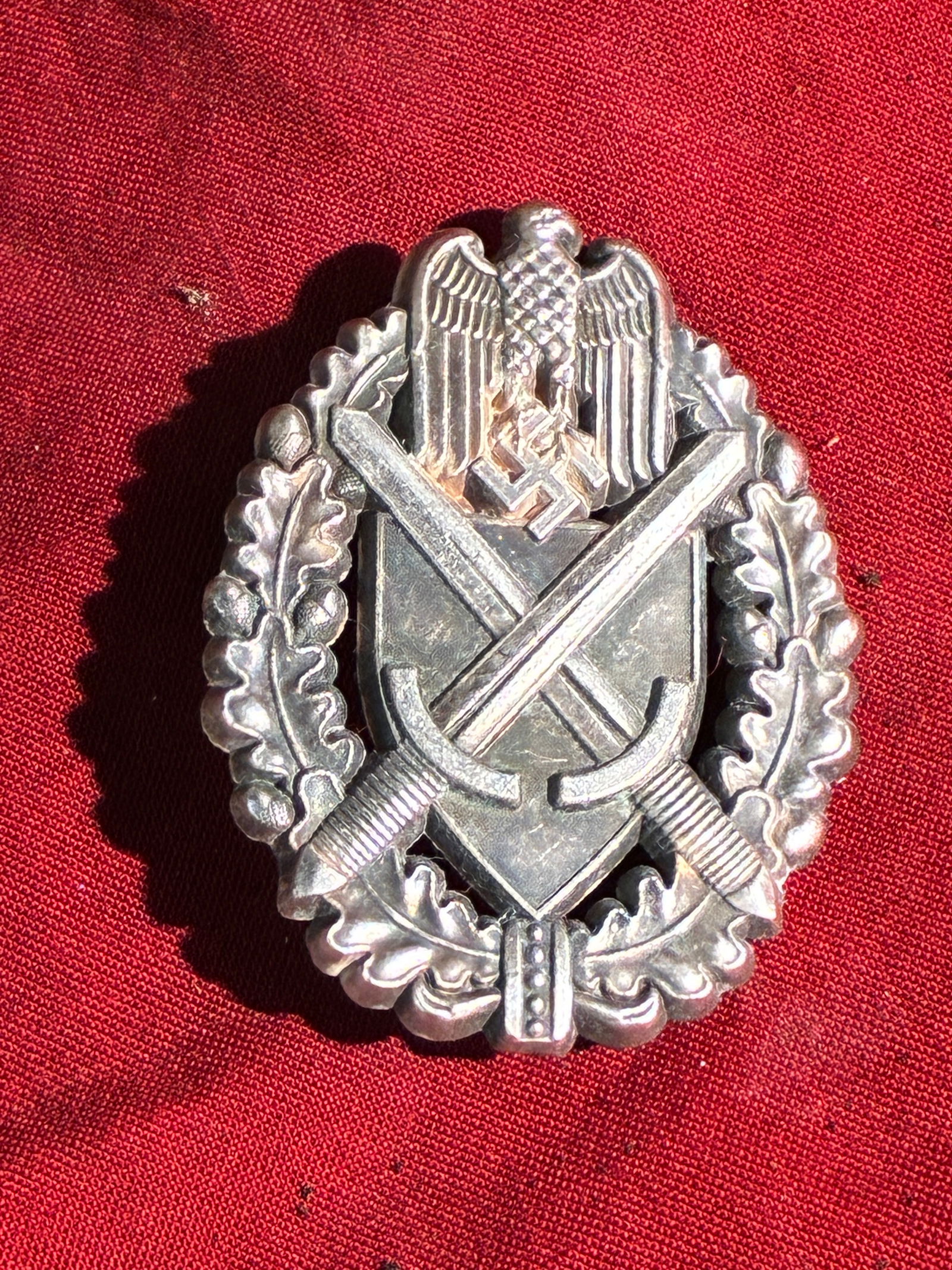 WW2 German Marksman Silver Grade Badge: WW2 German Marksman Silver Grade Badge. his metal badge, bearing the crossed sword and hammer motif surmounted by the German eagle and swastika, represents an insignia associated with the Politische B